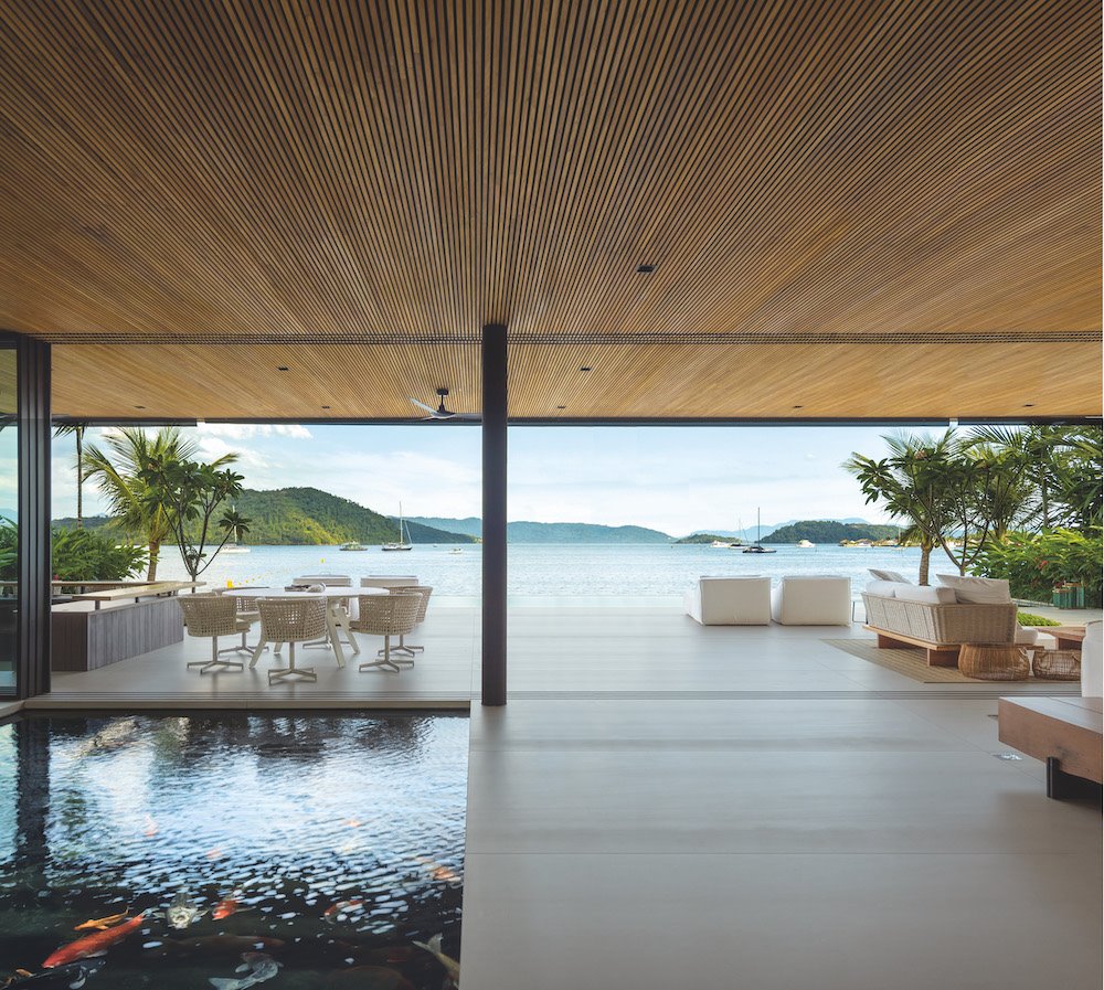 Salon con vistas al mar y lago con peces de una casa en Brasil