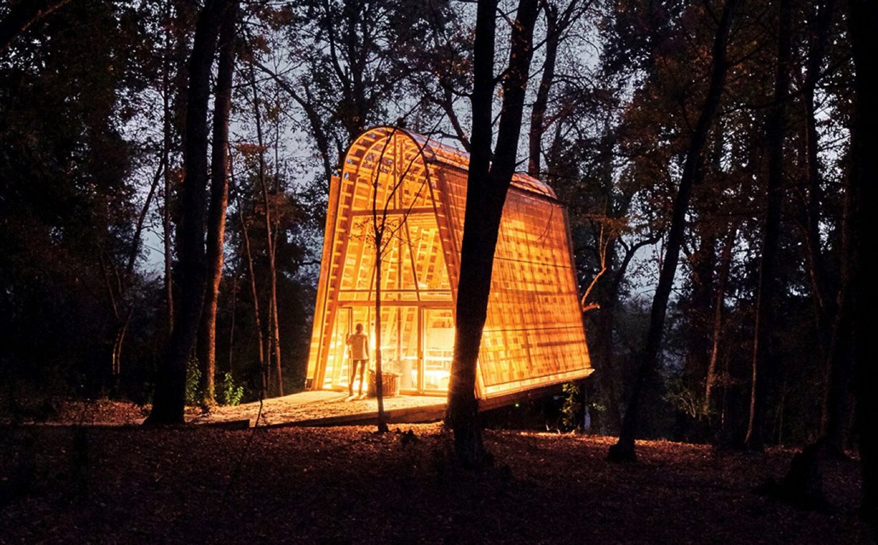 La casa tiene paredes inclinadas y un techo curvo formado por madera de pino chileno.