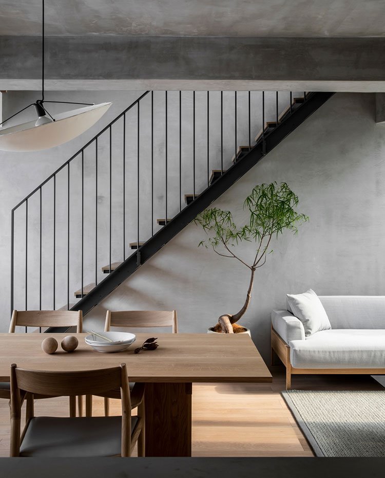 tokio. mesa-y-sillas-de-madera-luminaria-suspendida-con-pantalla-semicircular-escaleras-de-madera-y-acero-sofa-en-gris fc83f8a6 750x930