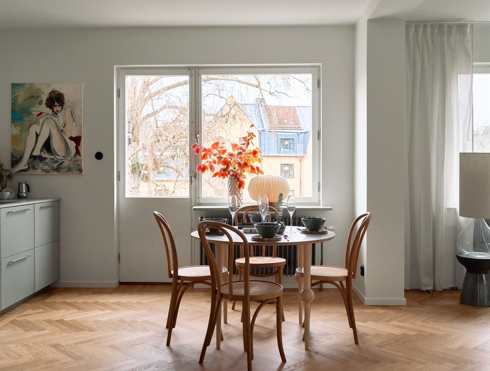 Piso en Suecia con interiores de estilo nordico comedor con mesa redonda y silla junto a la ventana