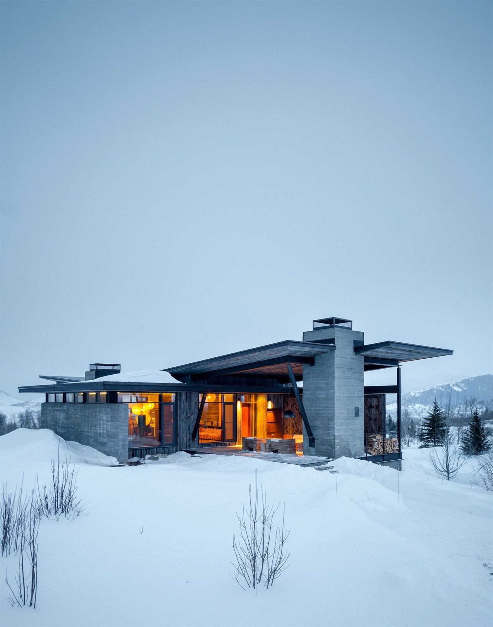 Exterior de una casa nevada con chimenea de piedra