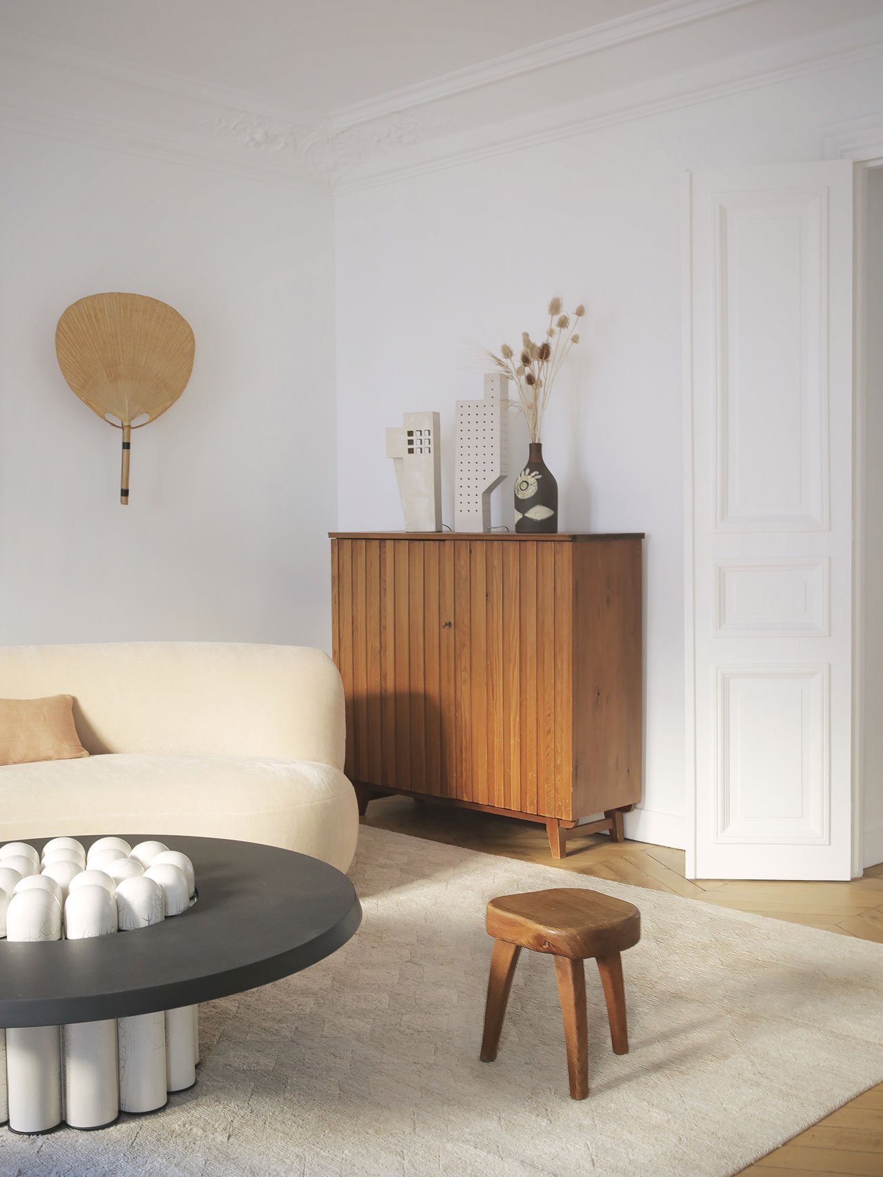 Salon con sofa curvado de un piso vintage en Paris puerta con moldura