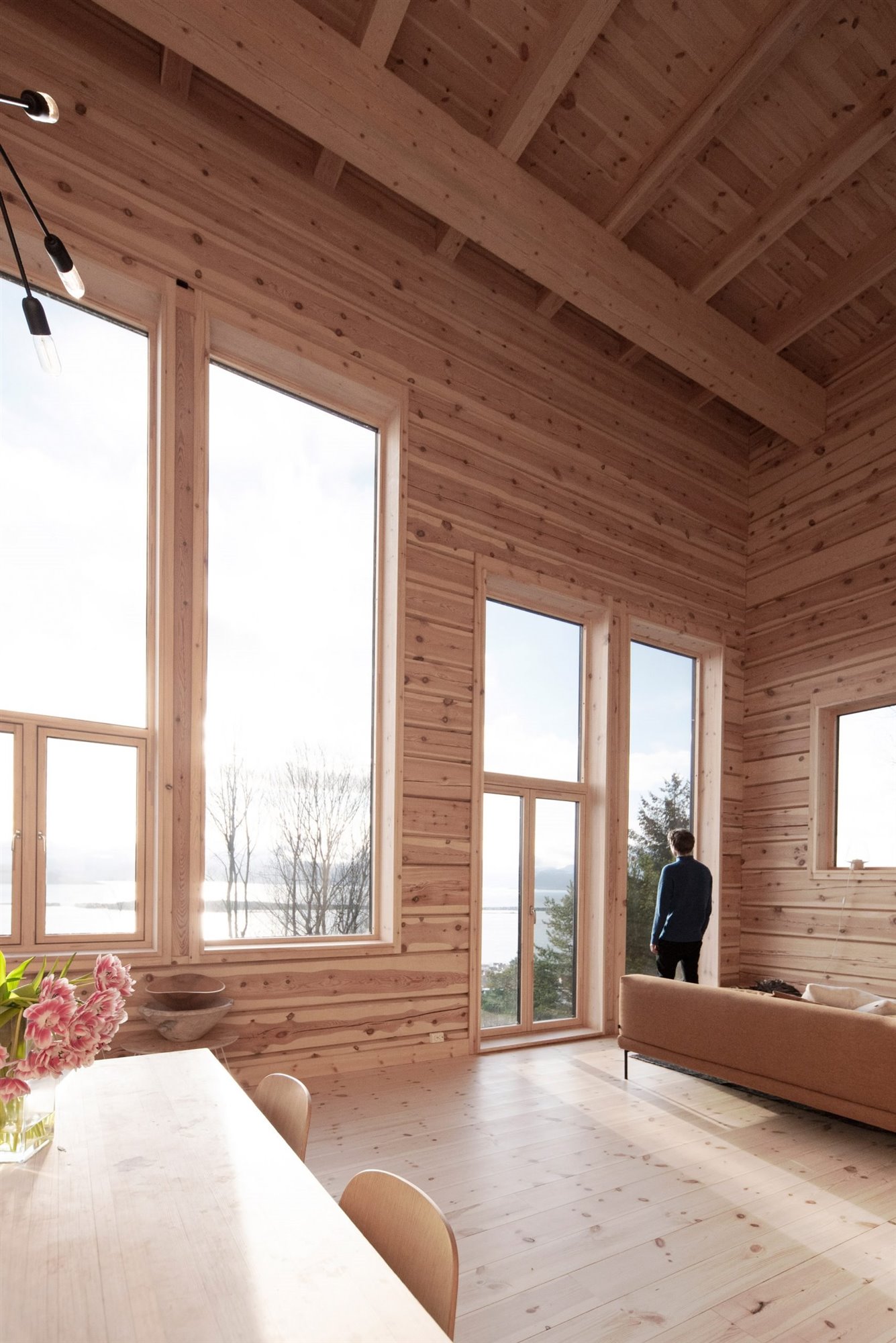 Salon con ventanas grandes de una cabaña en la nieve