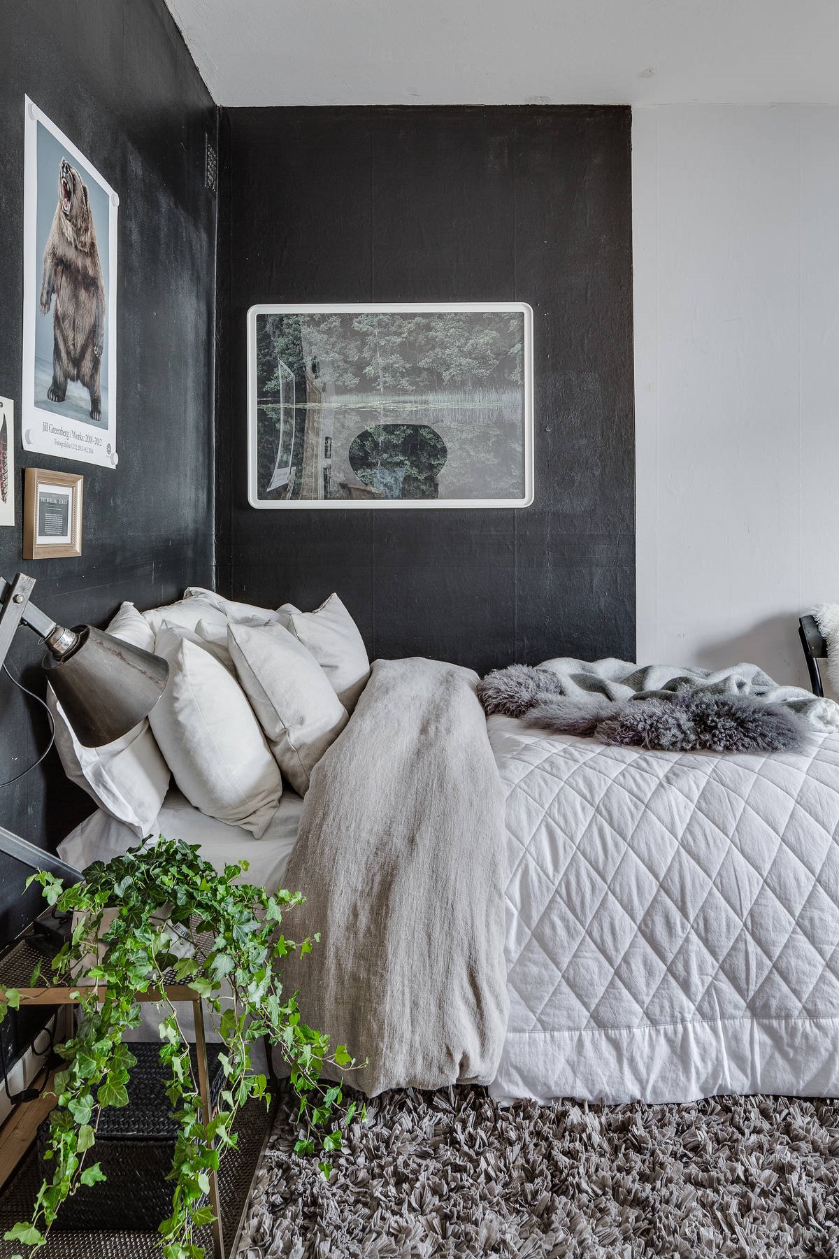 Dormitorio de un piso de pocos metros con pared cabecero de color negro
