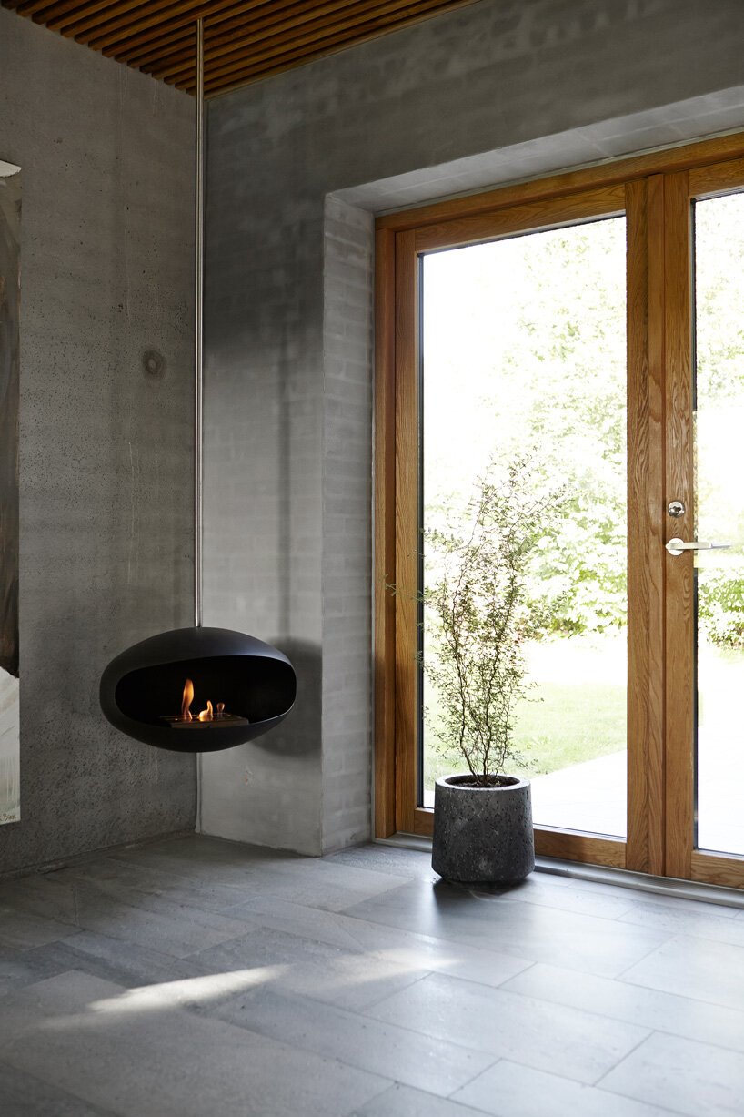 Casa con fachada de piedra y escalera de madera en Dinamarca chimenea