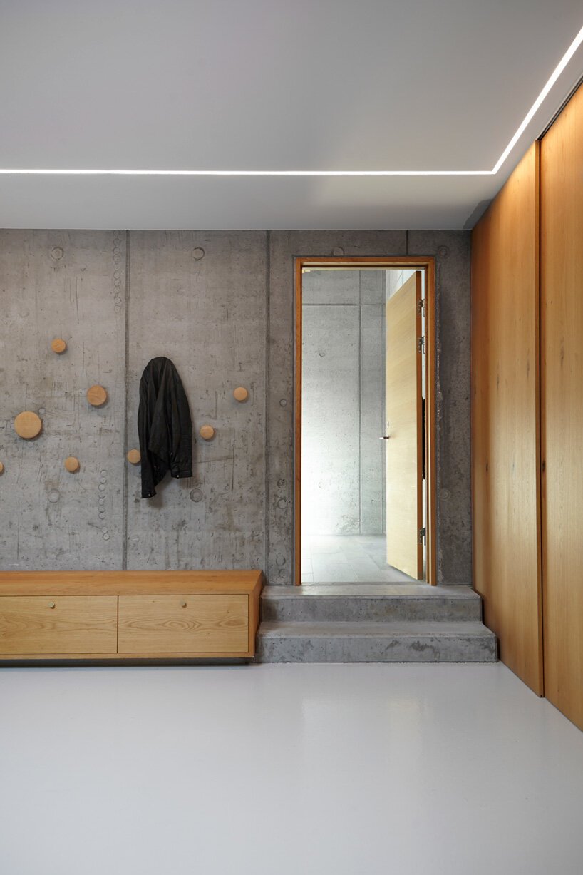 Casa con fachada de piedra y escalera de madera en Dinamarca entrada con perchero