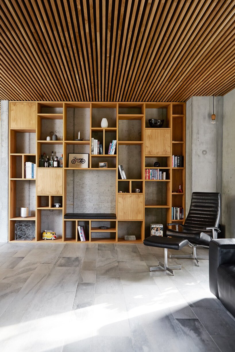 Casa con fachada de piedra y escalera de madera en Dinamarca salon con libreria