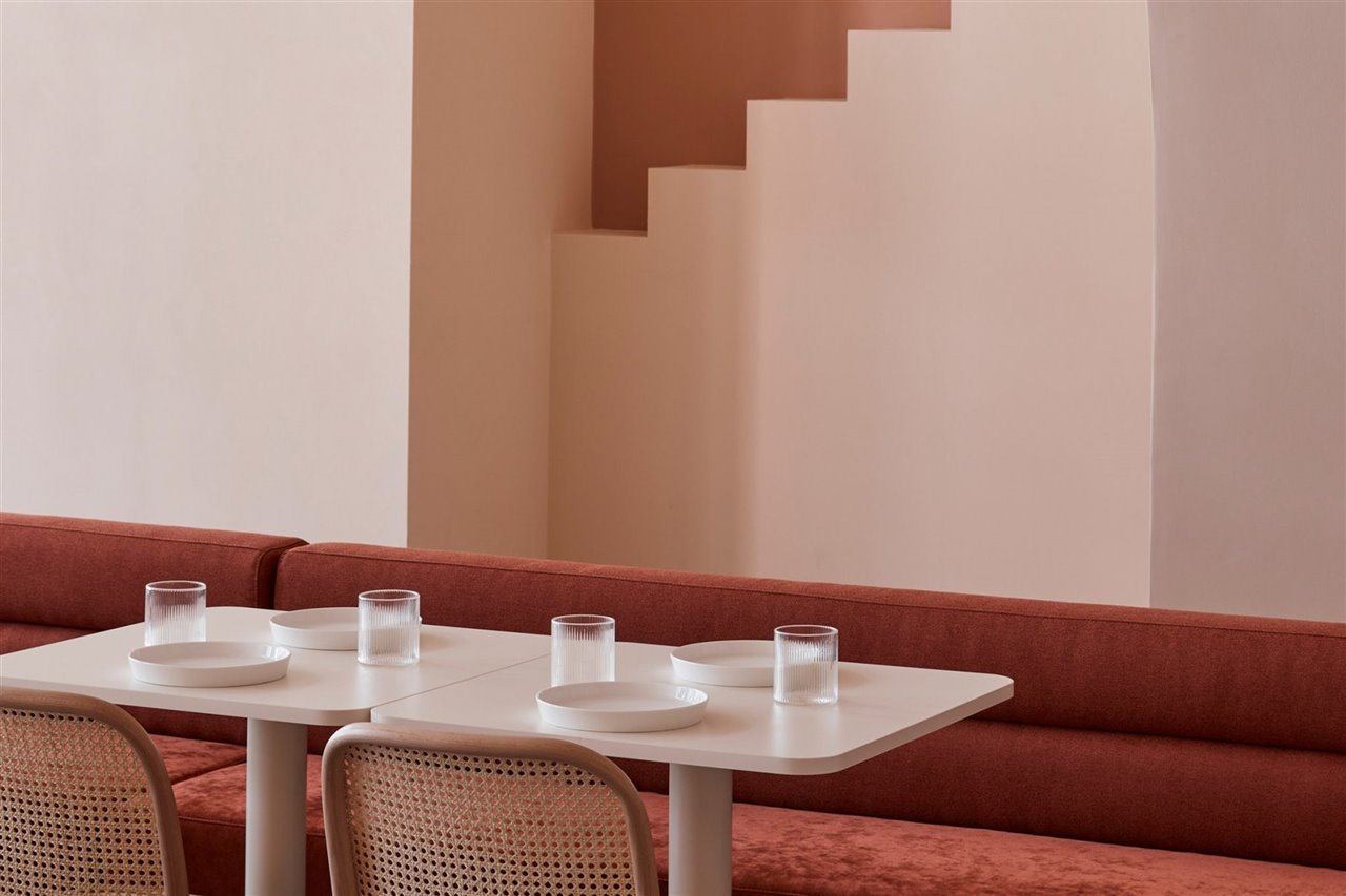 Cafe Budapest en Melbourne en color terracota con arcos y escaleras sofa de terciopelo
