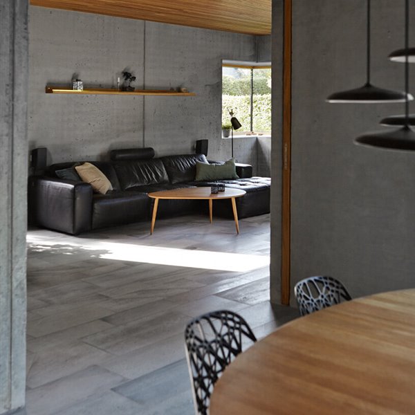 Interiores cálidos y una impresionante escalera de madera se dan cita en esta casa de hormigón en Dinamarca