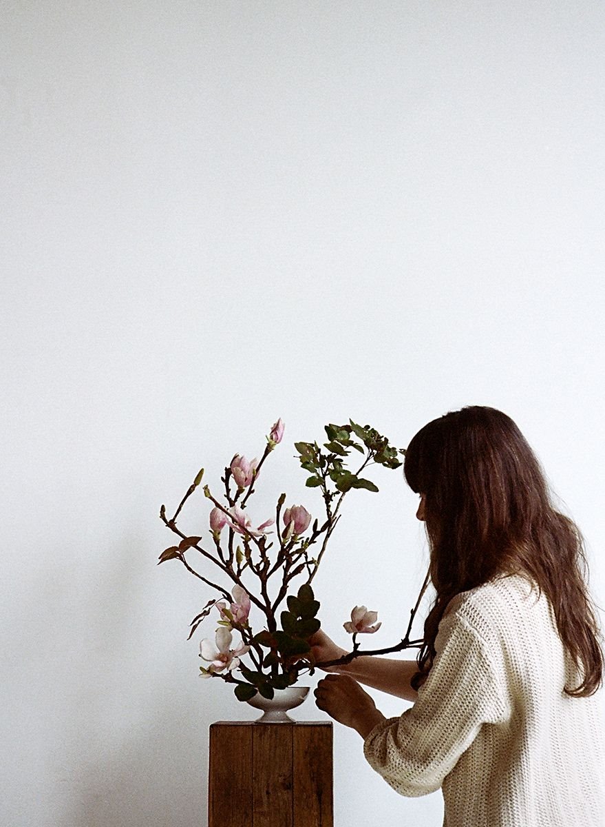 Mujer con un arreglo floral de ikebana