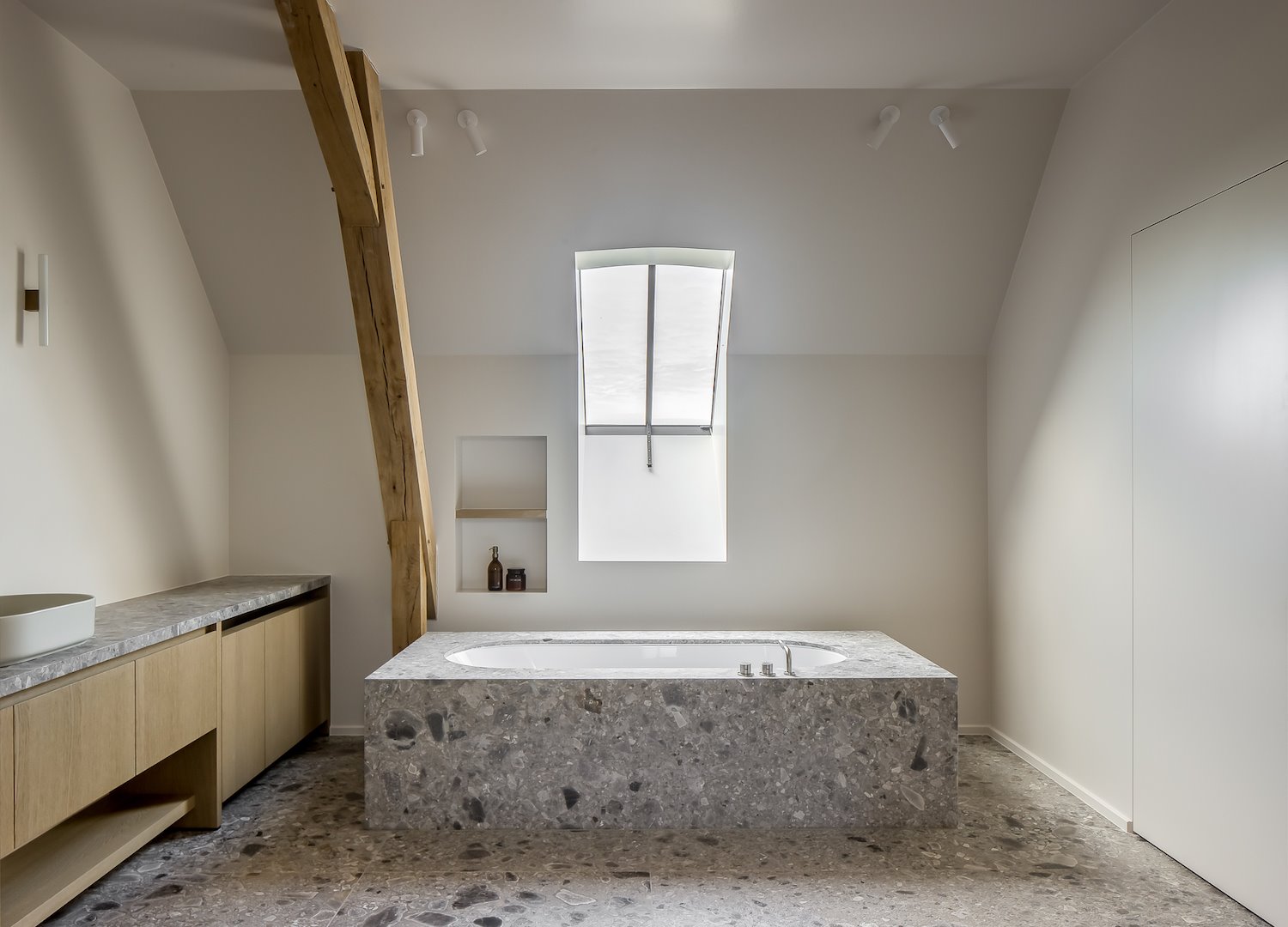 Baño en buhardilla con bañera de piedra natural de una casa en Belgica