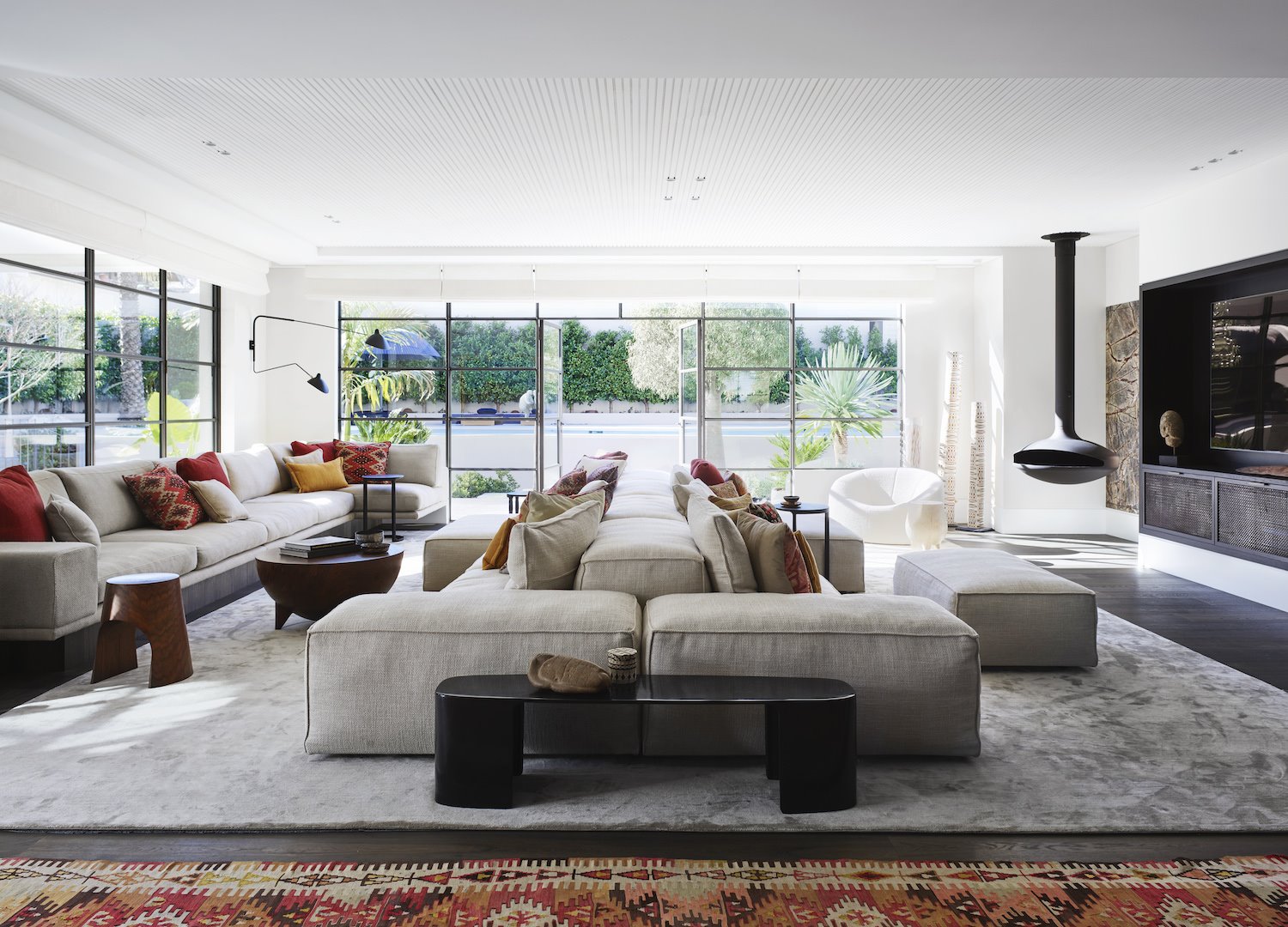 Salon con sofas de color blanco chimenea y alfombras. Salón