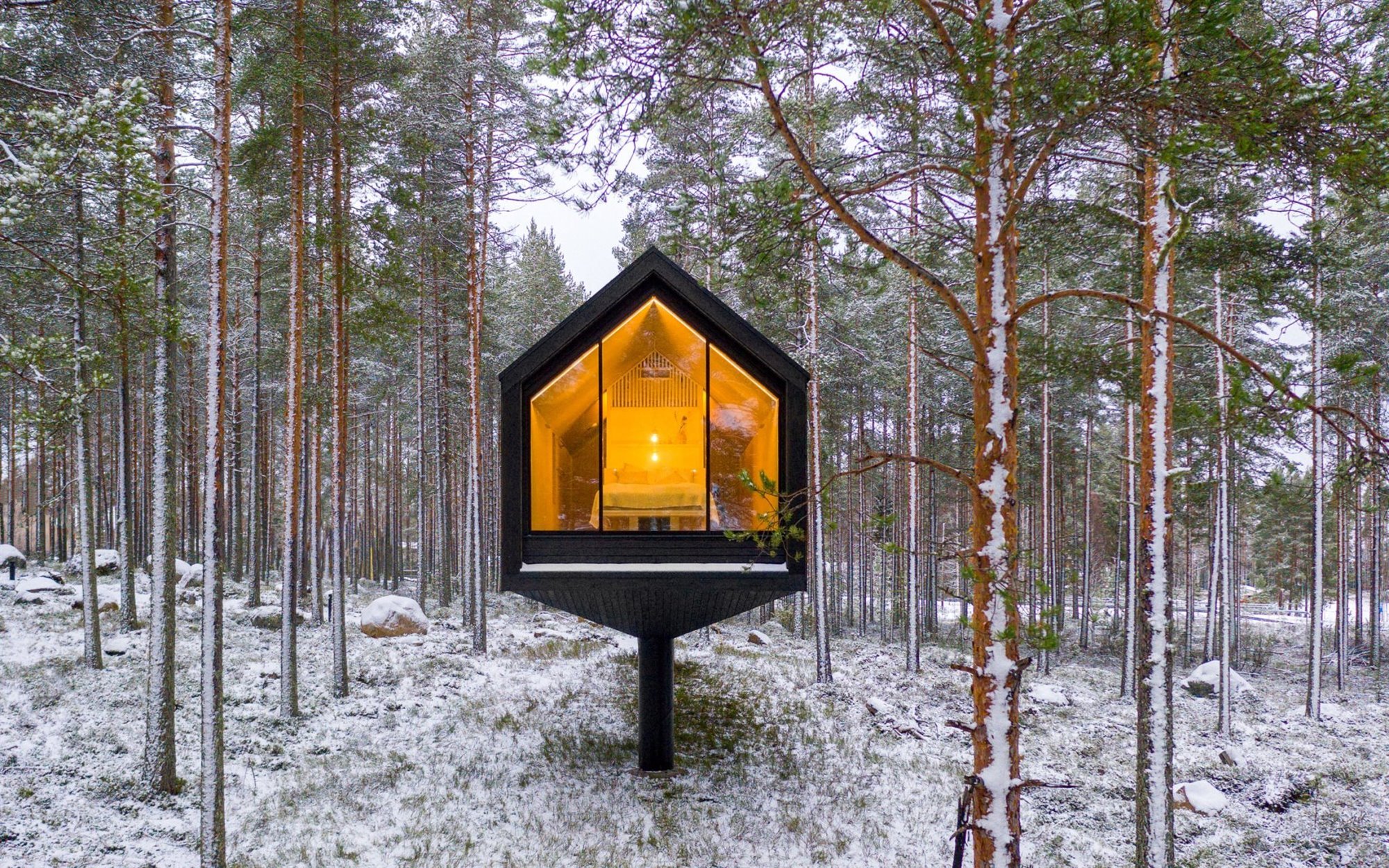 Una cabaña de madera en un bosque de Finlandia rodeada de nieve Una cabaña de madera en un bosque de Finlandia rodeada de nieve