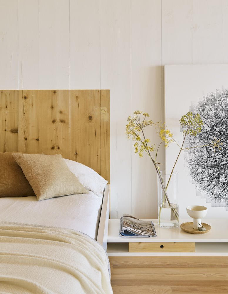 Cama con cabecero de madera y sabanas de fibras naturales