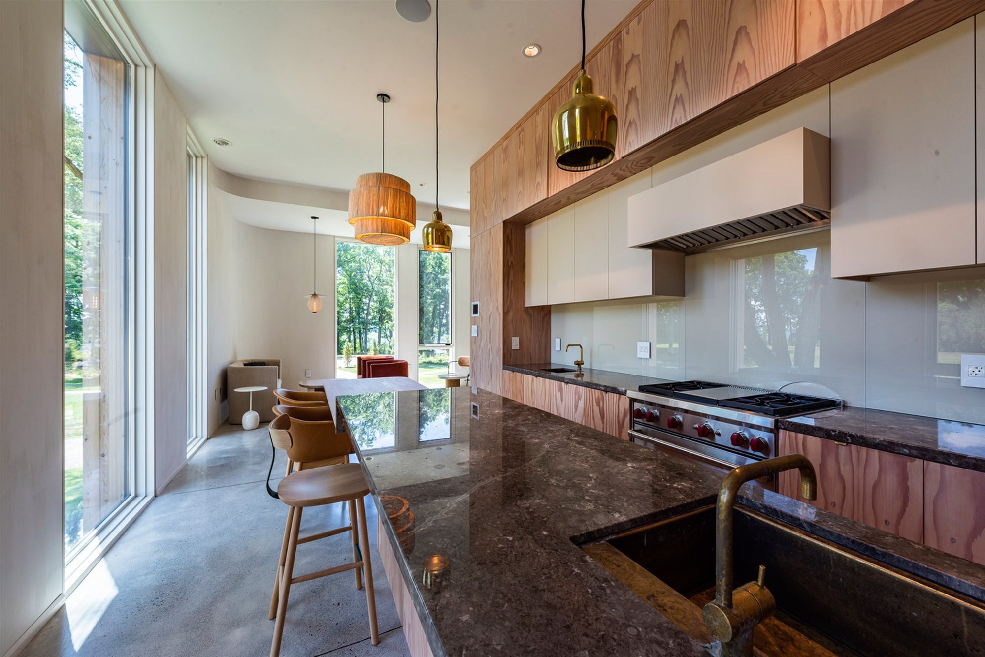 Casa moderna en Canada con fachada doblada en color negro cocina en madera y marmol