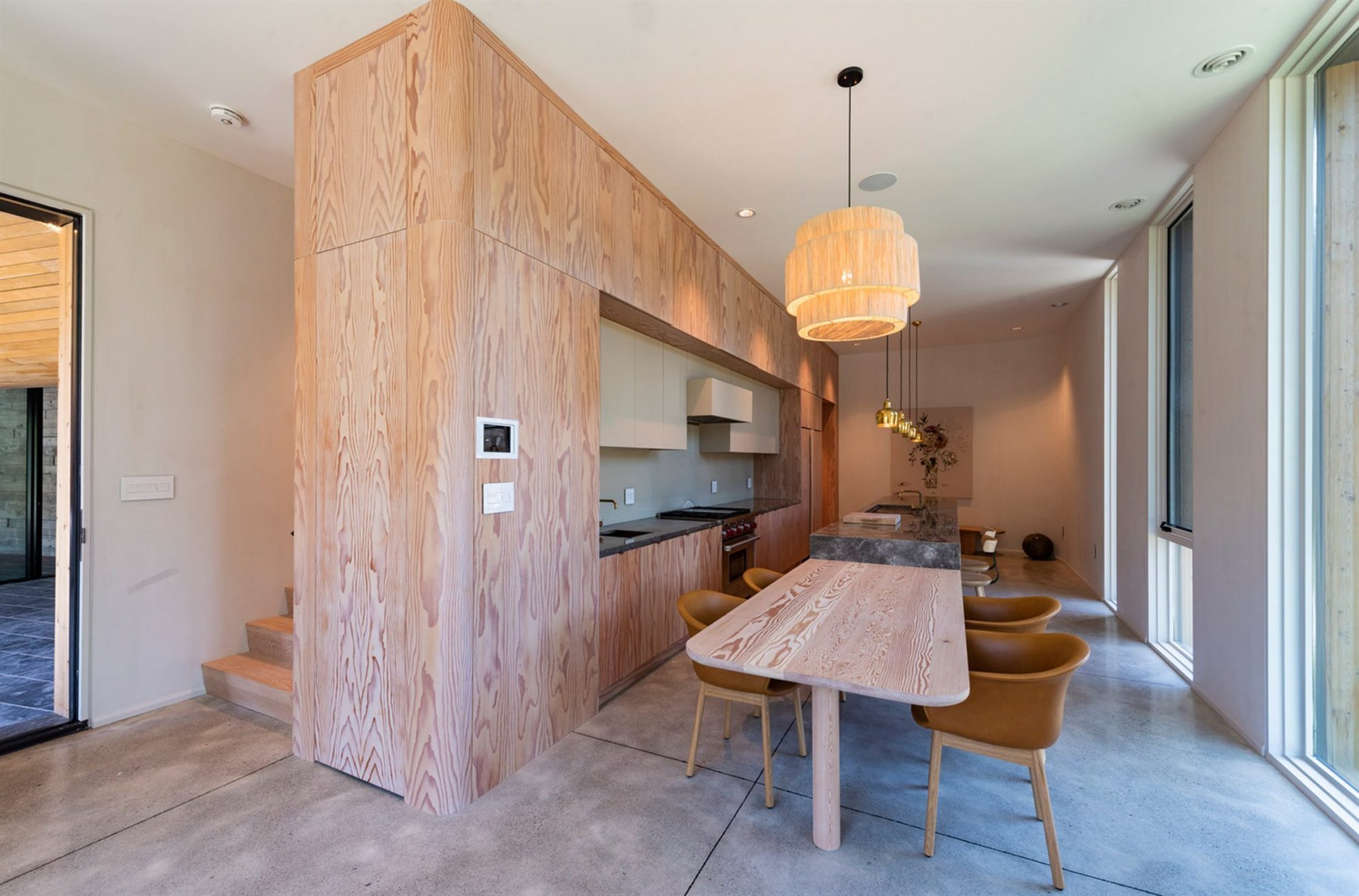 Casa moderna en Canada con fachada doblada en color negro comedor de madera