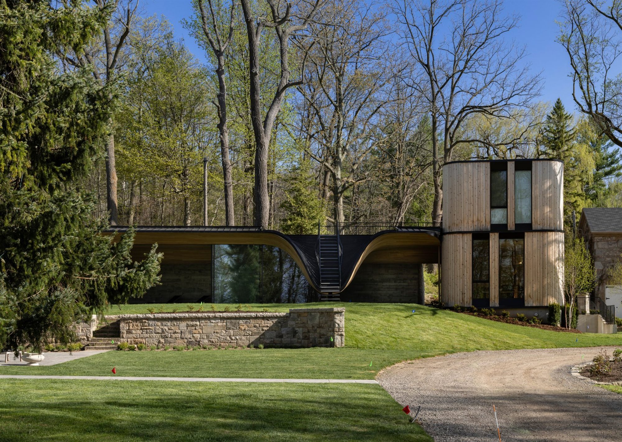 Casa moderna en Canada con fachada doblada en color negro en un bosque