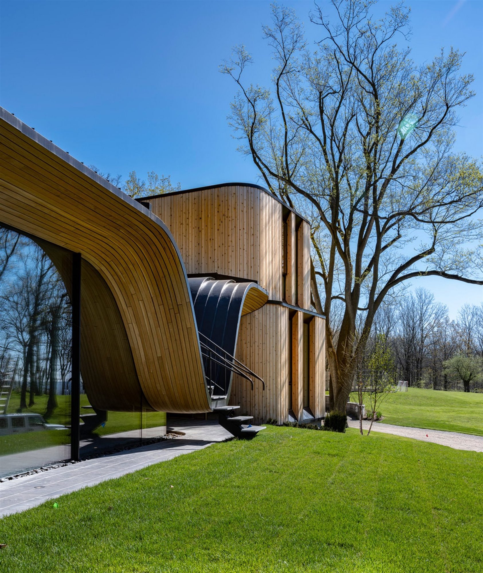 Casa moderna en Canada con fachada doblada en color negro jardin