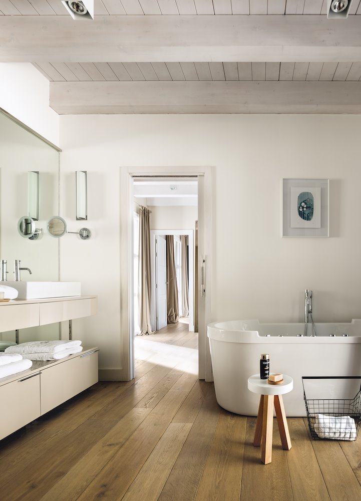 Baño con bañera y suelo de madera