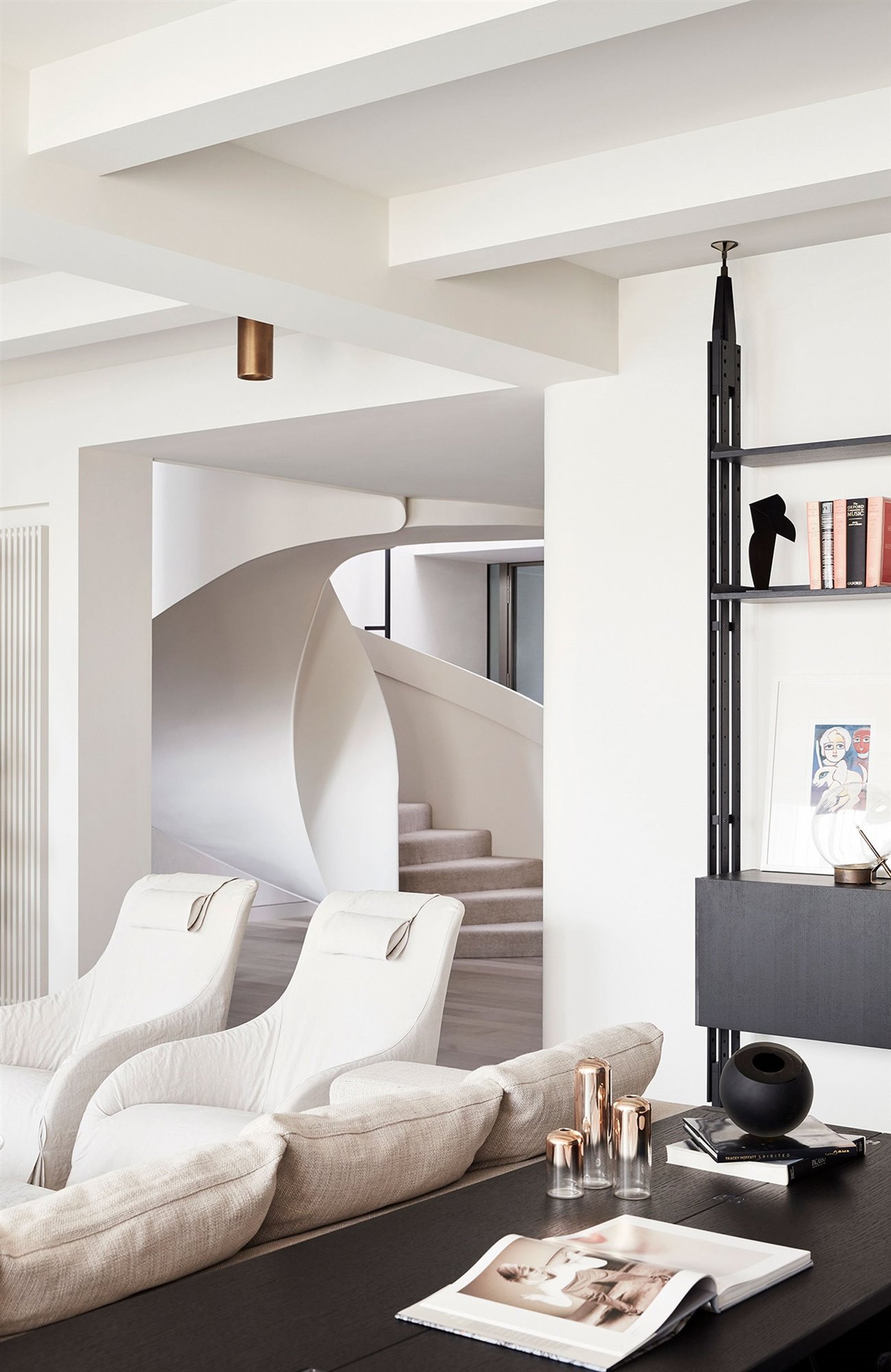 Casa en australia con escalera de caracol salon con butacas blancas