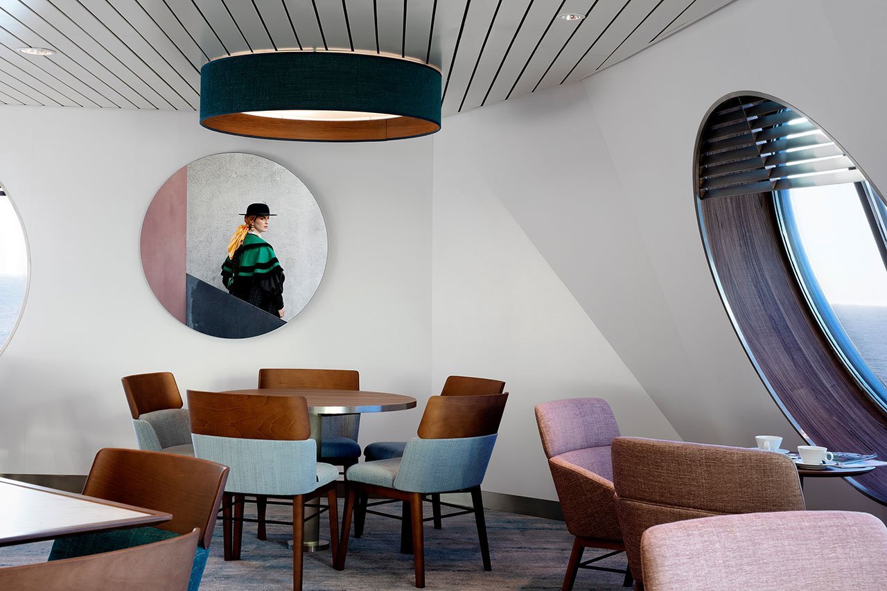 Salon comedor del ferry galicia con cuadros redondos y sillas en azul y rosa