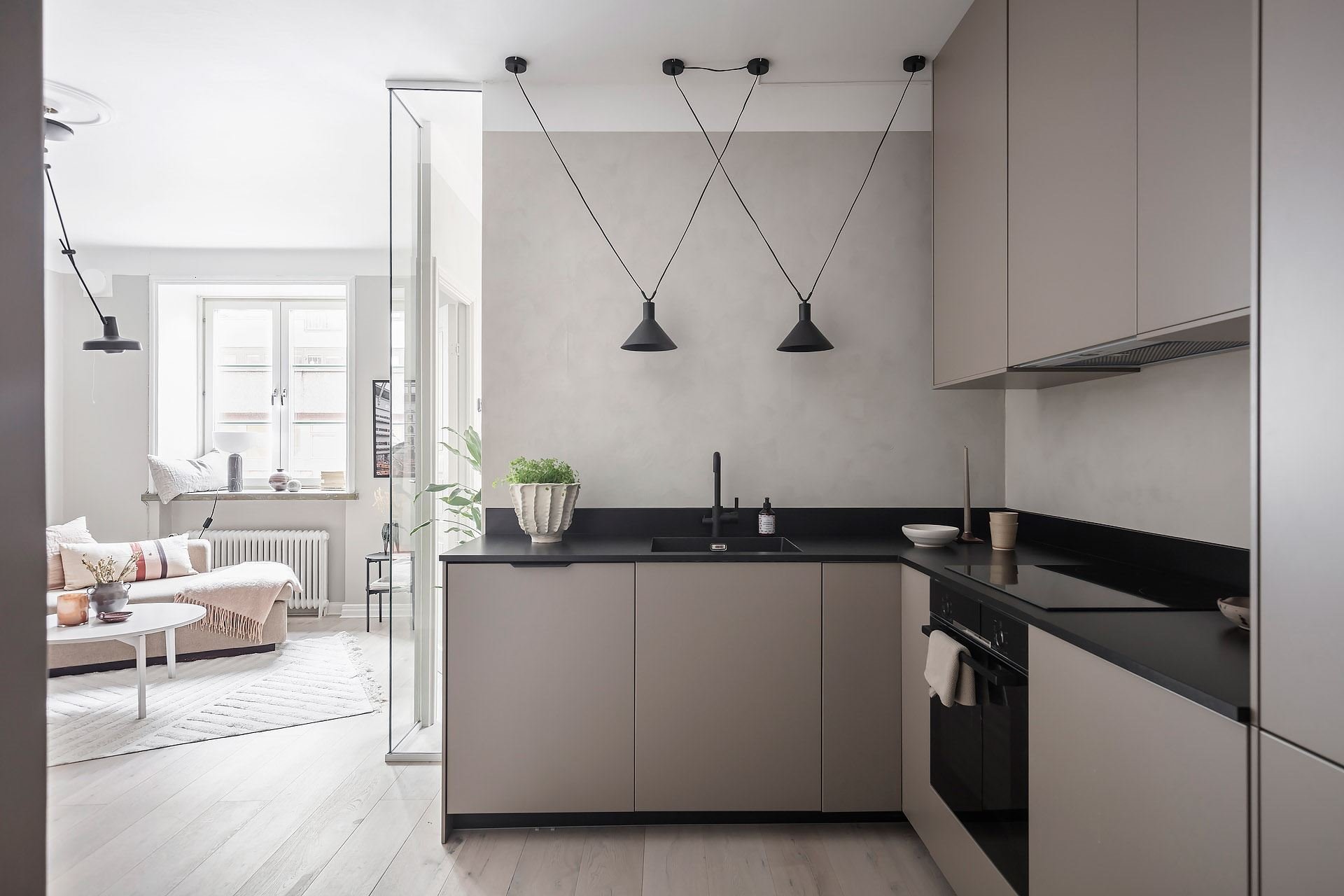 Piso en Estocolmo con paredes en gris y rosa cocina comedor salon lamparas negras