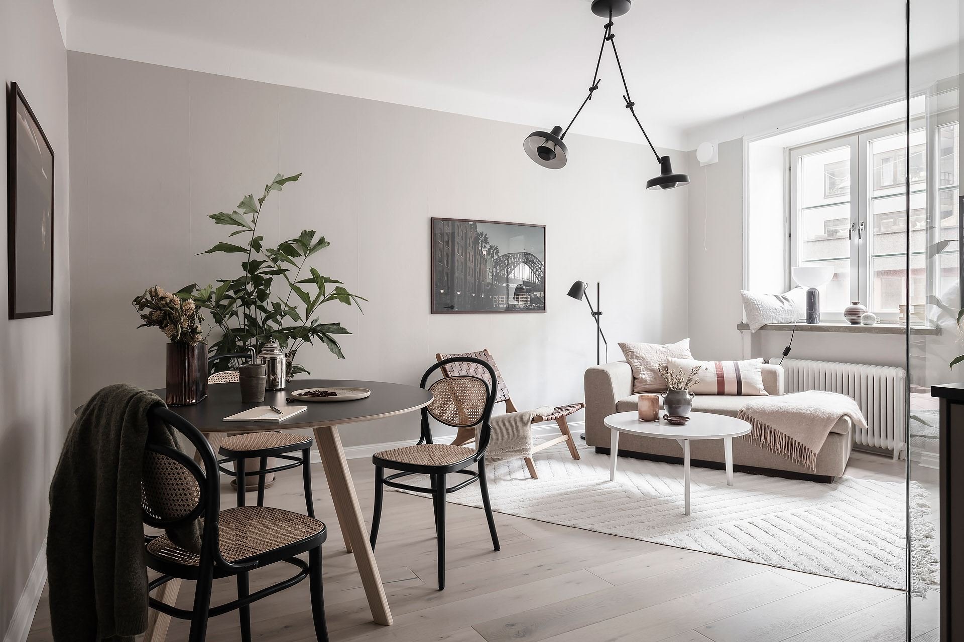 Piso en Estocolmo con paredes en gris y rosa cocina comedor salon sillas en negro