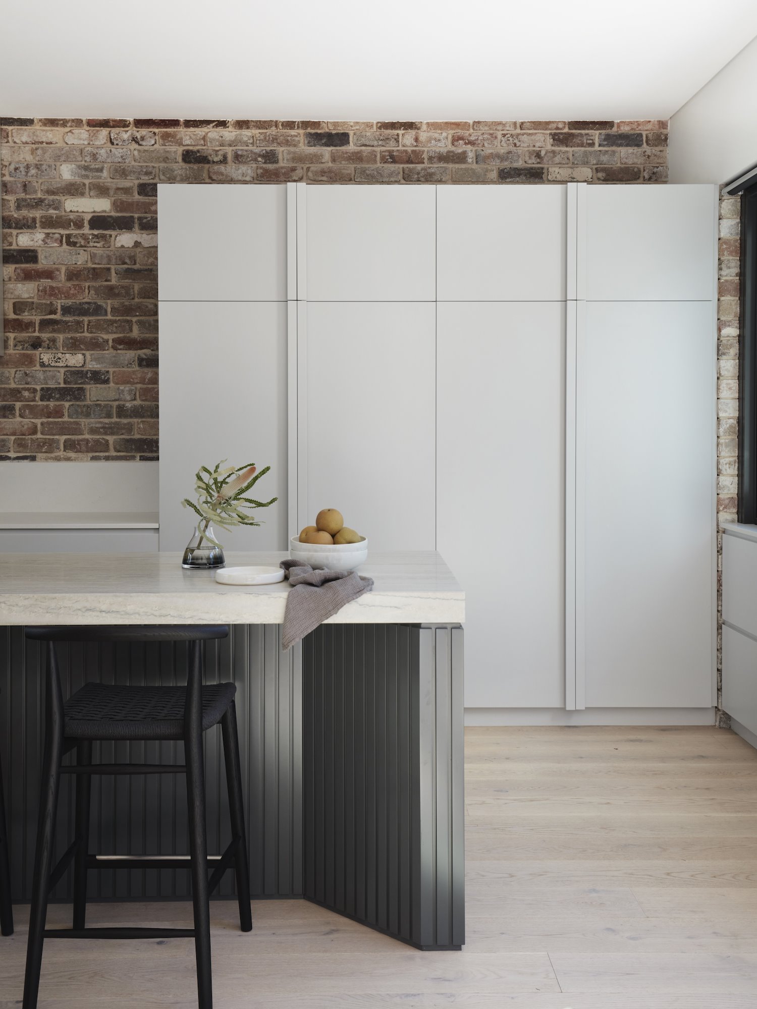 Casa moderna con paredes de ladrillo en Australia cocina con muebles negros