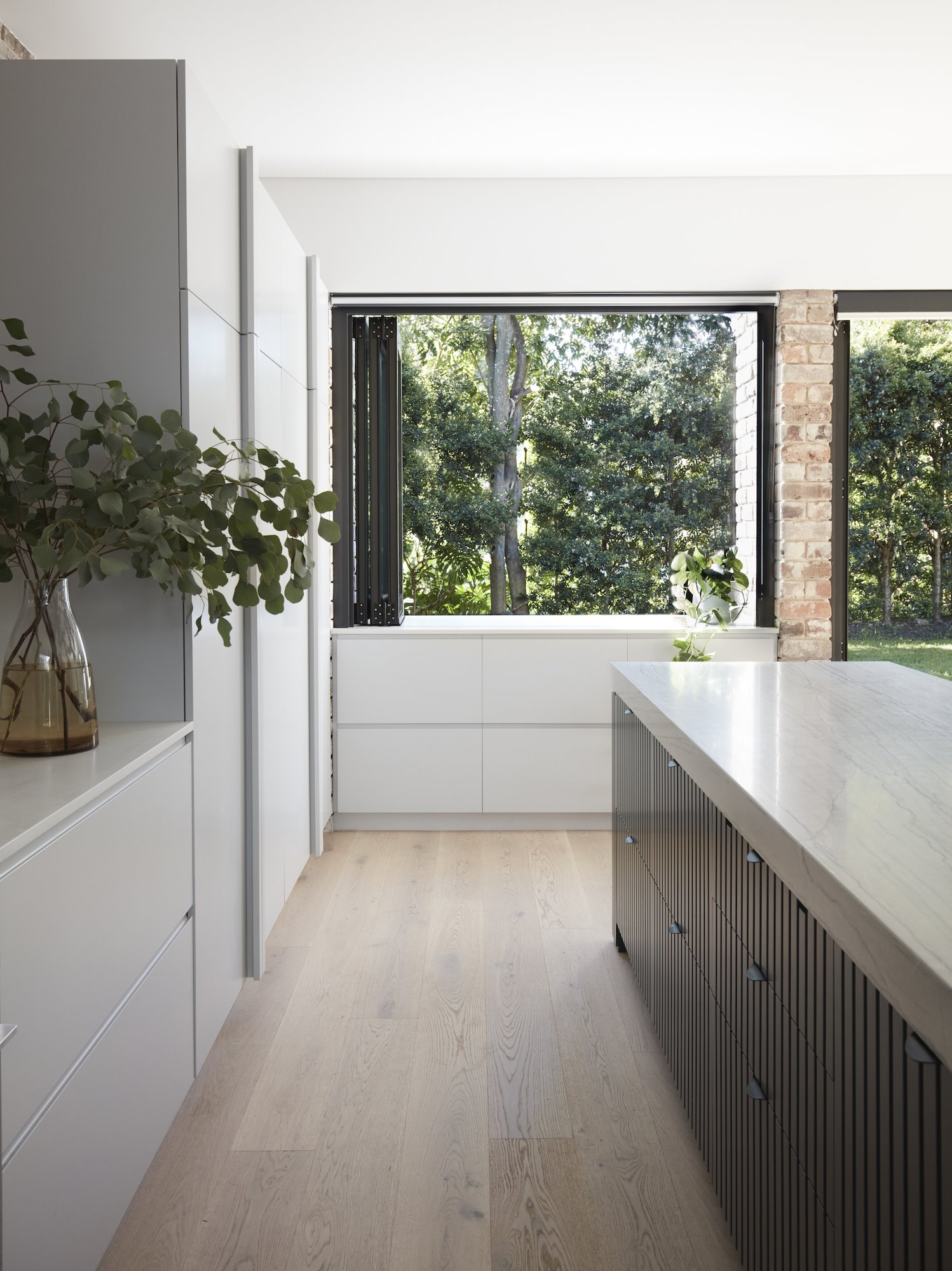 Casa moderna con paredes de ladrillo en Australia cocina con suelo de madera