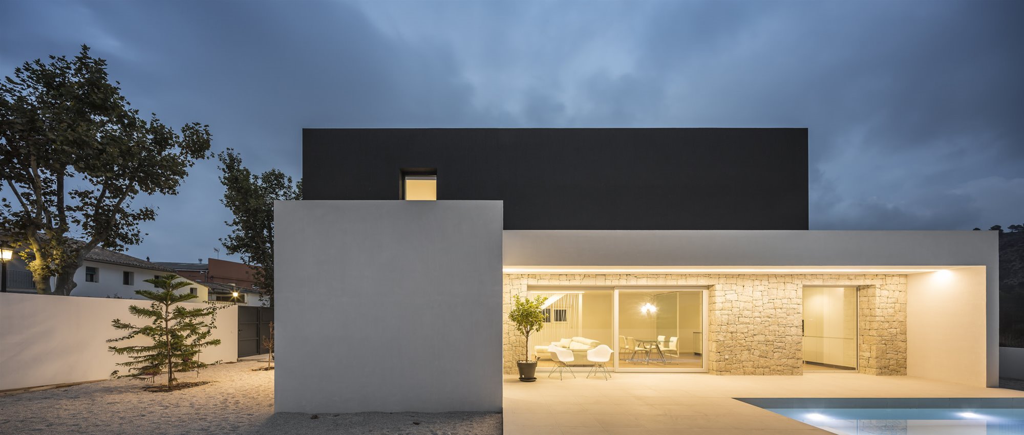 Casa moderna con fachada en blanco y negro en Valencia piscina de noche