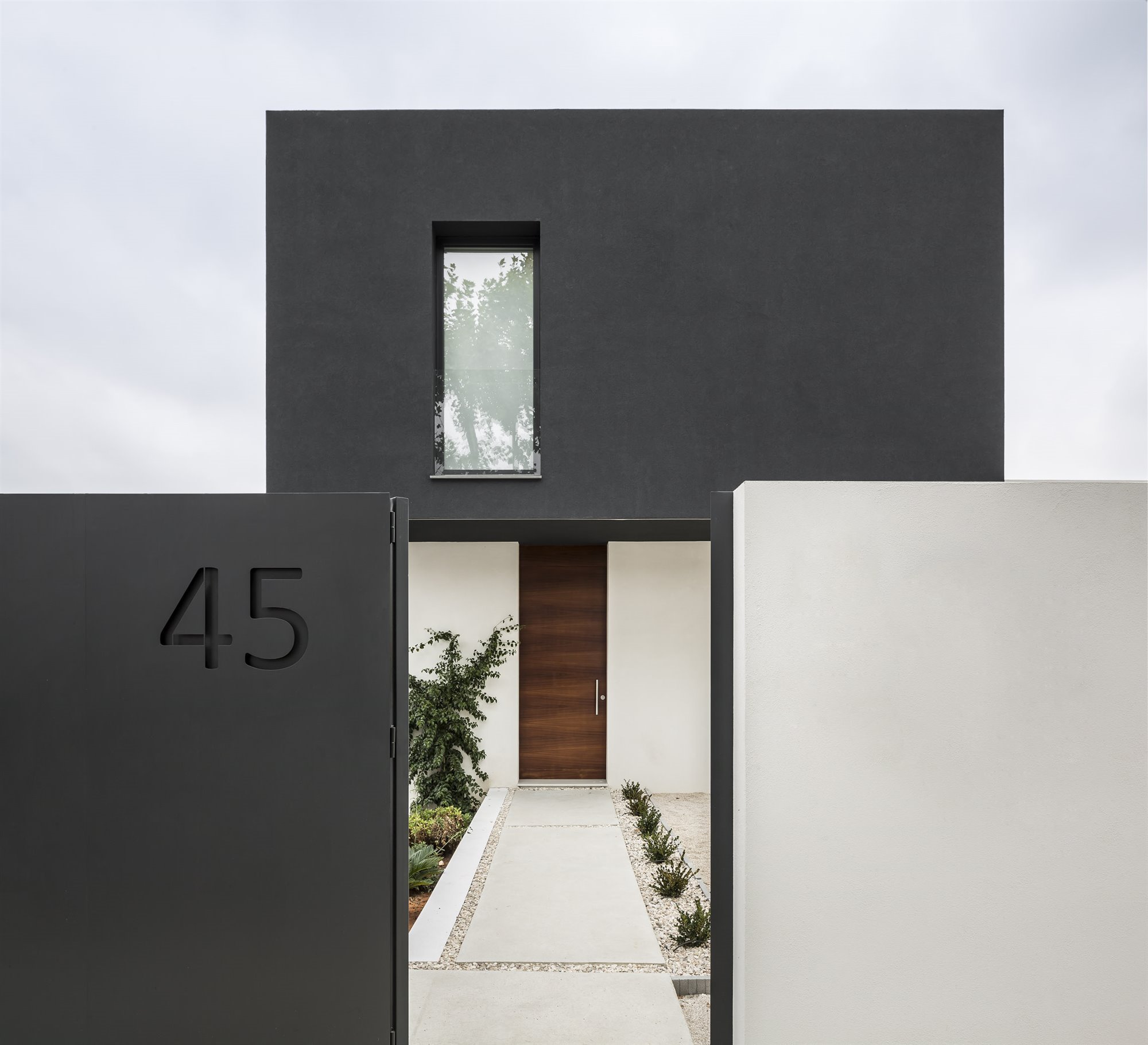 Casa moderna con fachada en blanco y negro en Valencia puerta entrada