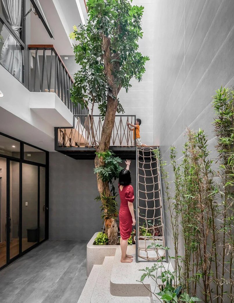 Una casa moderna con patios interiores llenos de plantas y luz en Vietnam