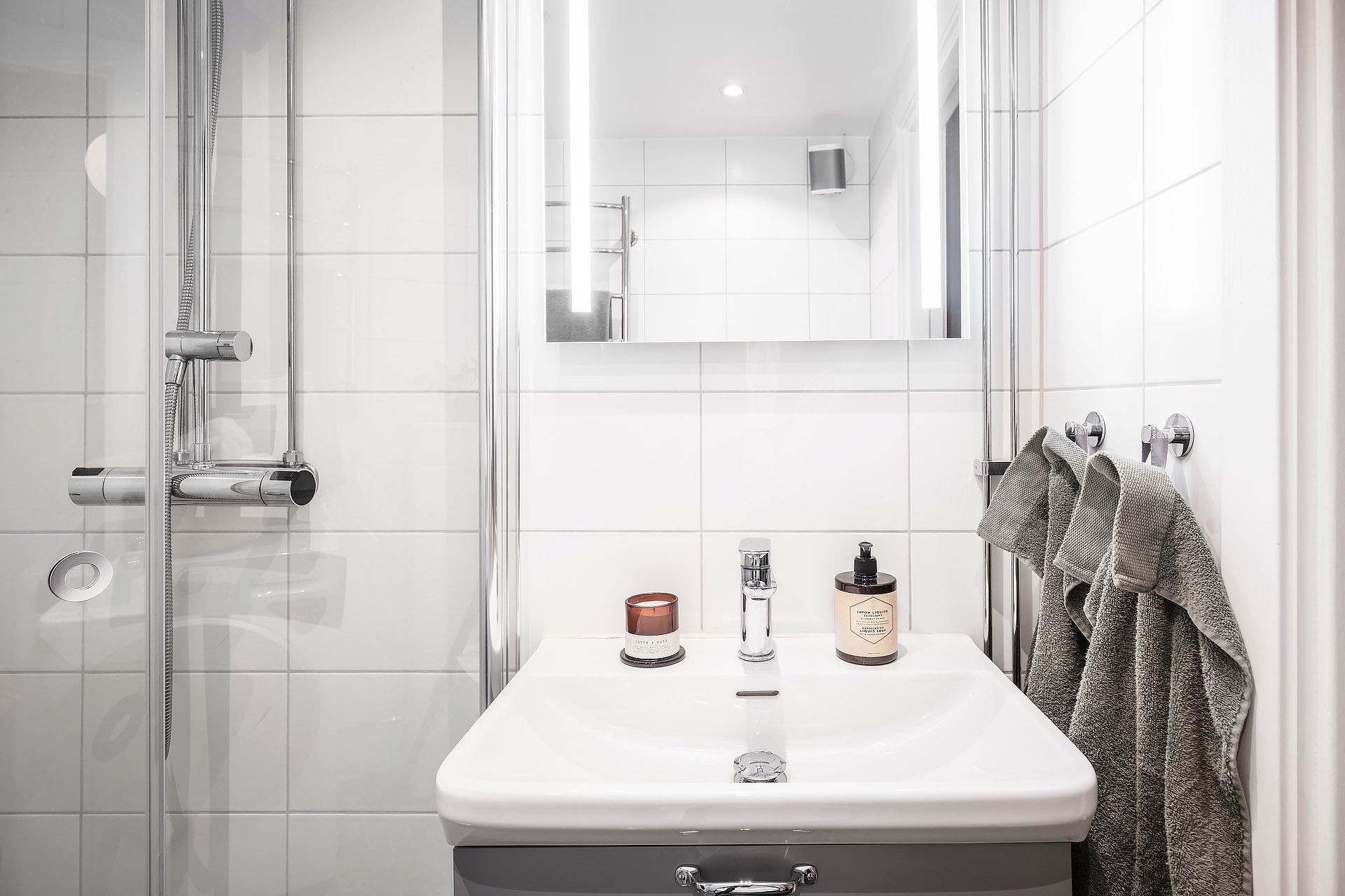 Piso pequeño con decoracion moderna en Suecia baño con espejo y lavamanos