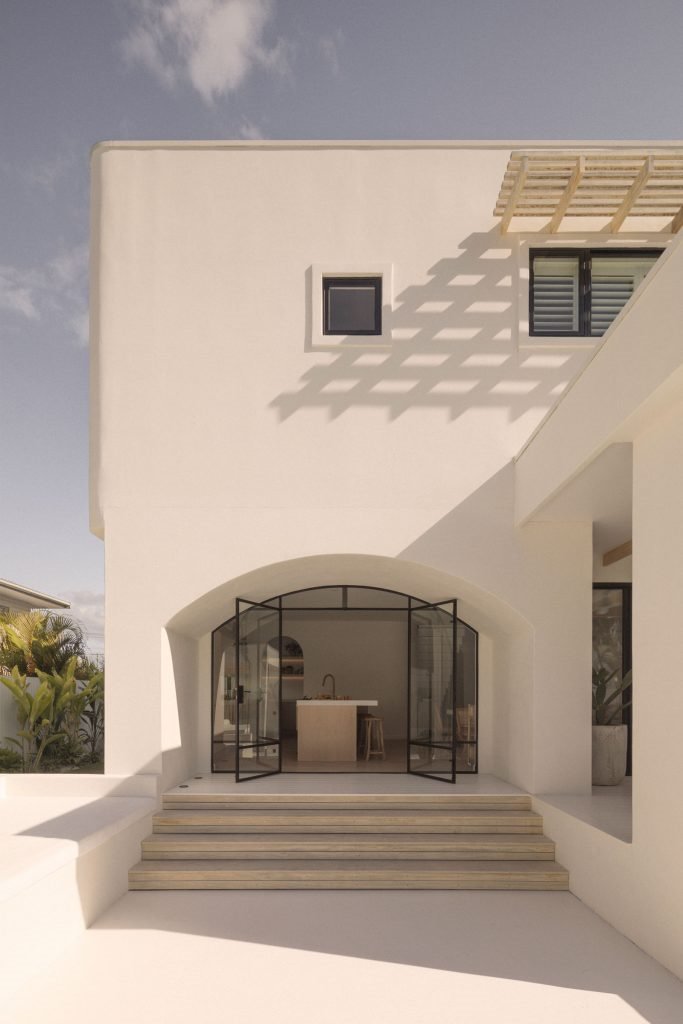 Casa junto a la playa de Australia con paredes blancas encaladas y decoracion moderna entrada