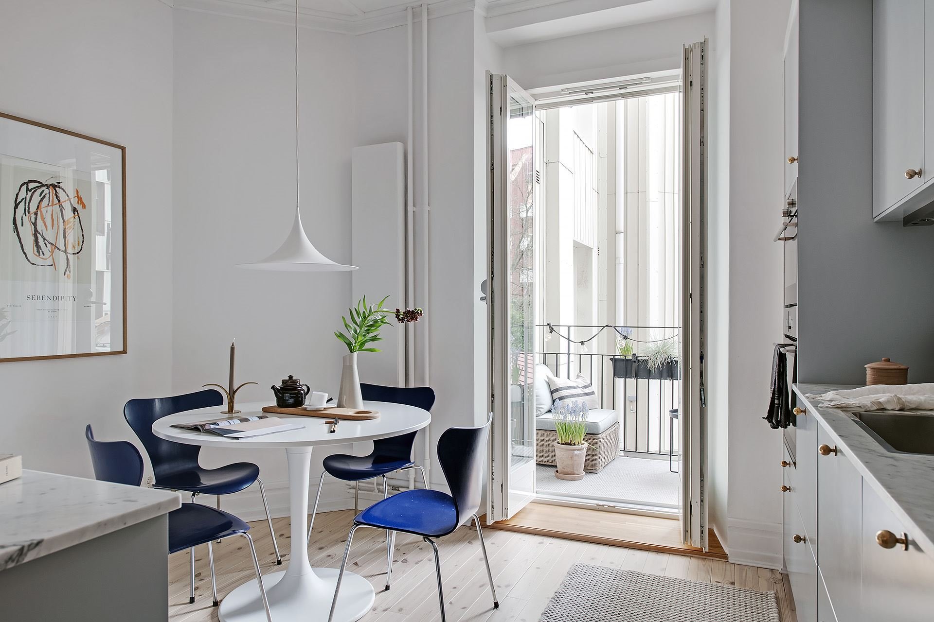 Piso con decoracion nordica moderna y paredes pintadas en color gris comedor con mesa redonda y sillas azules