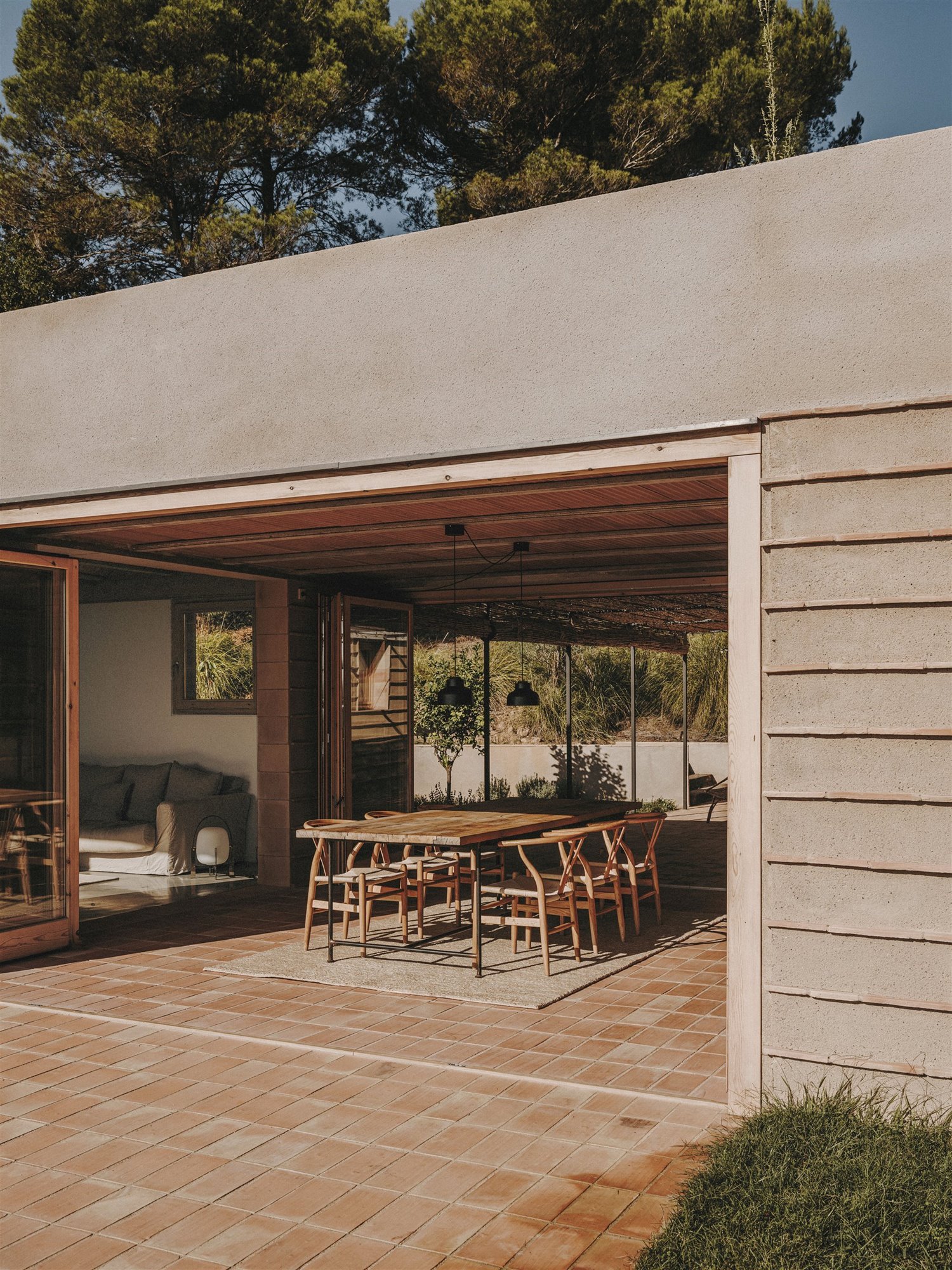 Casa moderna en el campo del estudio de arquitectura Mesura porche con comedor exterior suelo de ladrillo