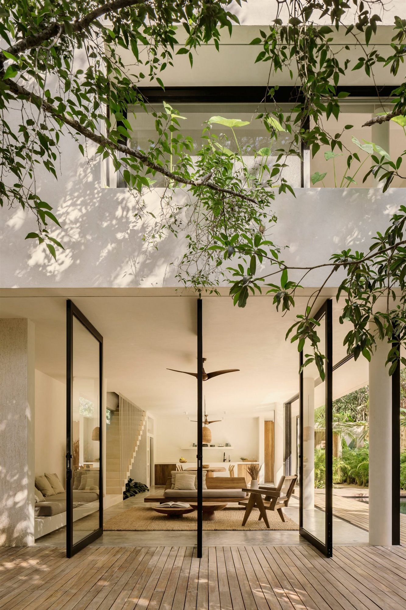 Casa Areca en Tulum Mexico con interiores de color ocre y piscina entrada salon con ventialdor