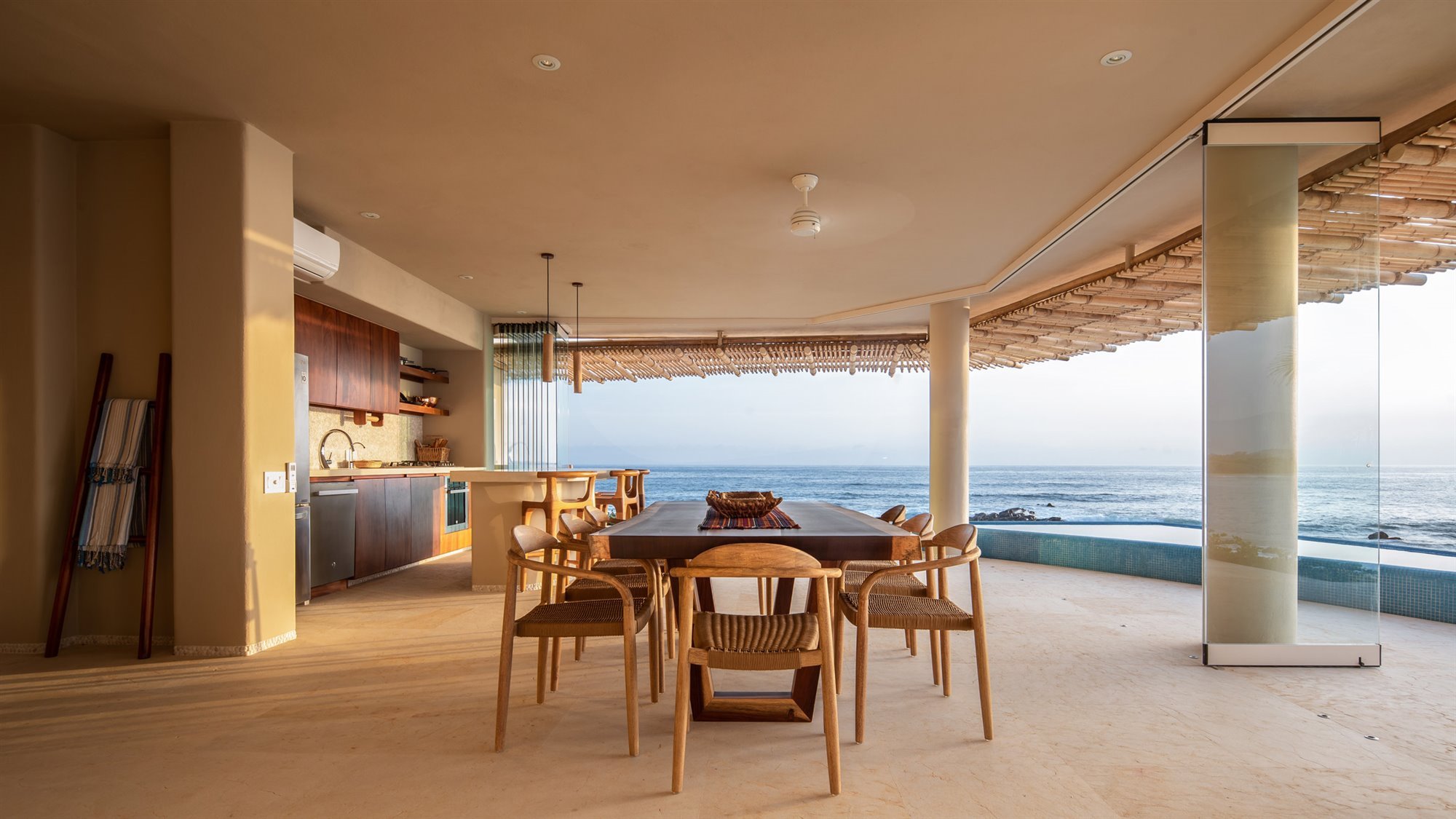 Casa en la playa con interiores de color ocre comedor con vistas al mar
