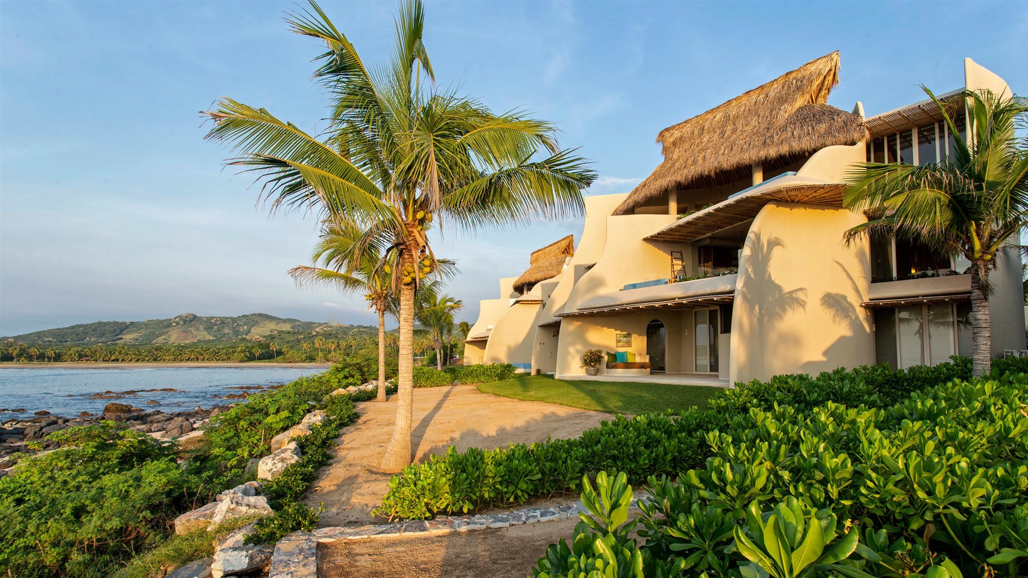 Casa en la playa con interiores de color ocre fachada junto al mar