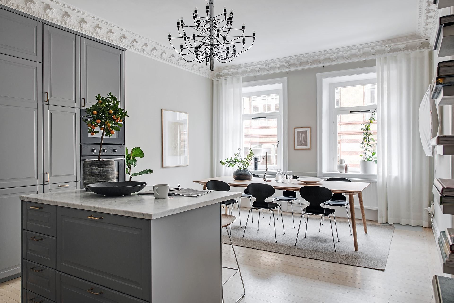 Piso con decoracion nordica y paredes en color gris con molduras cocina abierta al comedor