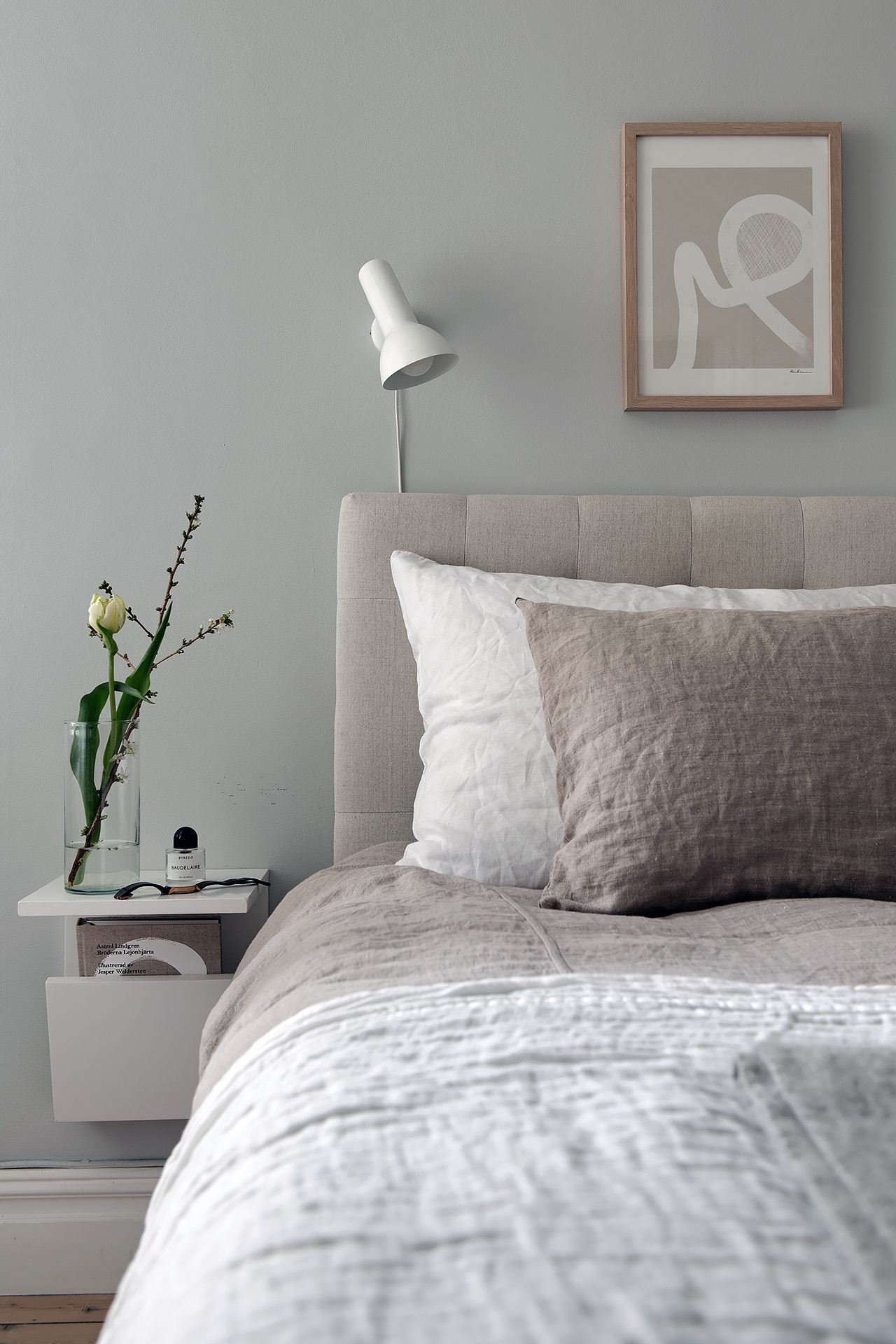 Piso con decoracion nordica y paredes en color gris con molduras dormitorio detalle de la cama