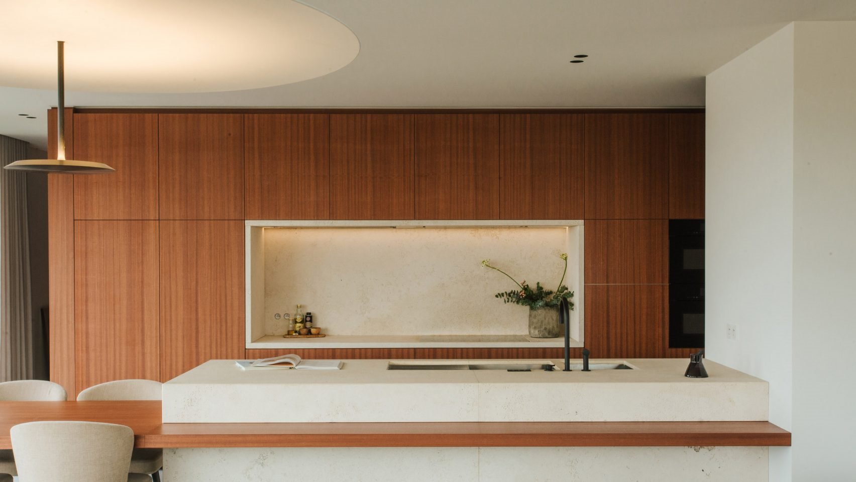 Piso moderno en belgia por studio Jo con interiores de madera cocina abierta con lampara dorada