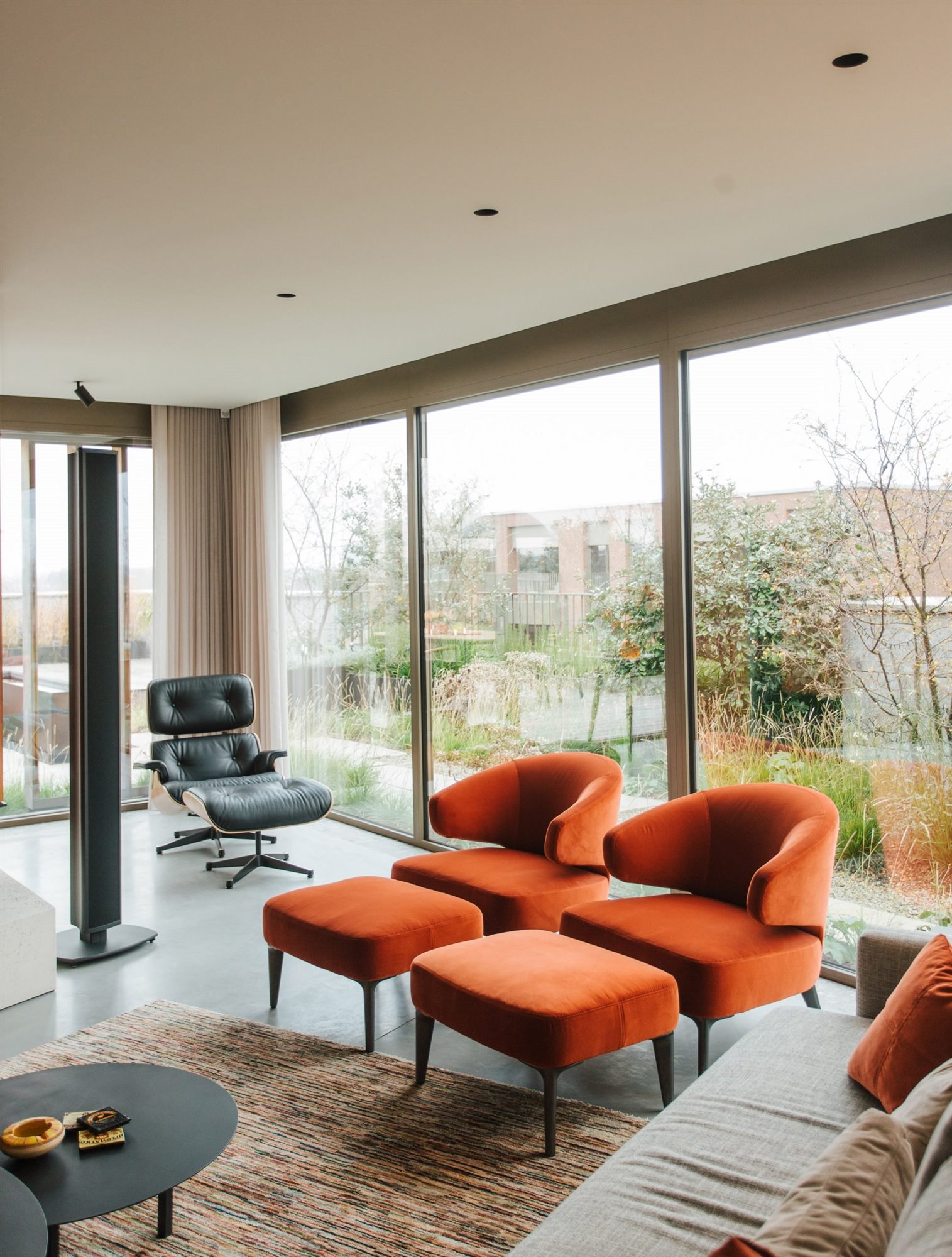 Piso moderno en belgia por studio Jo con interiores de madera salo con sillones naranjas