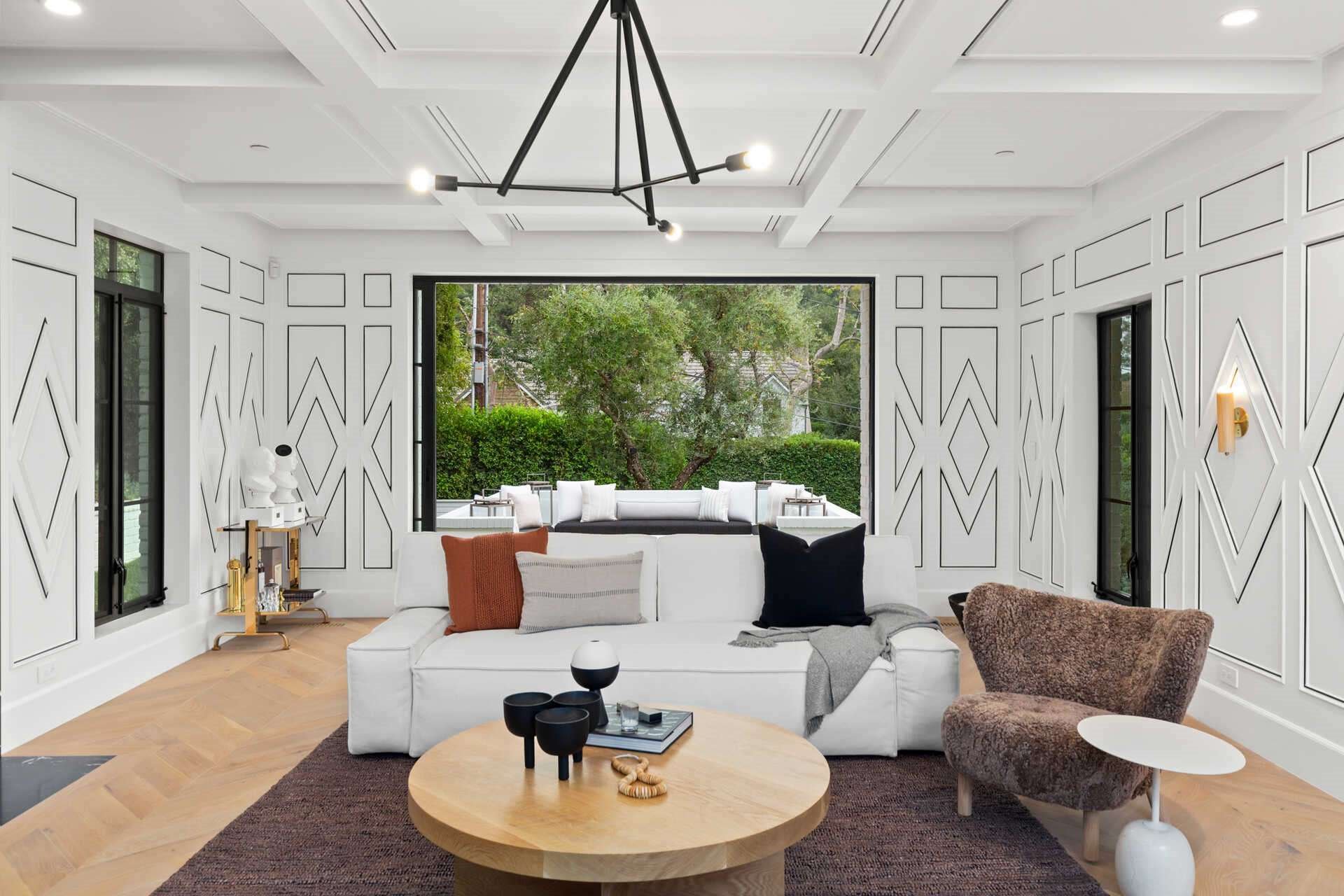 Casa Rihanna Beverly Hills salon con sofa blanco y molduras en el techo