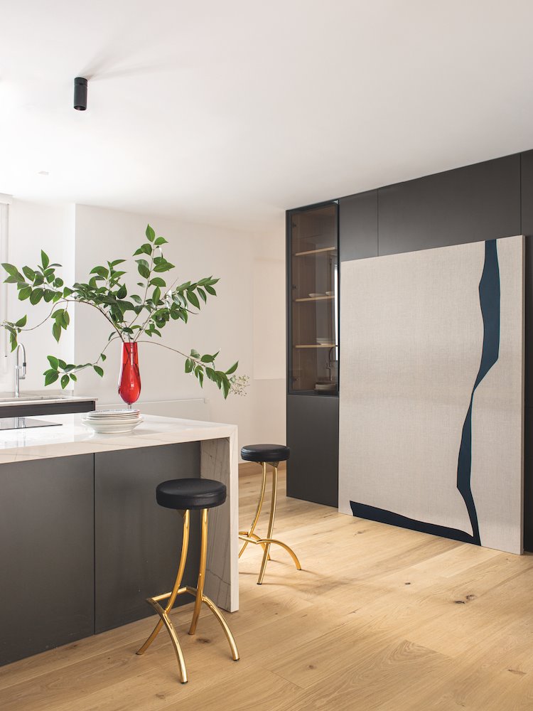 Cocina con taburetes metalicos de un apartamento en Madrid