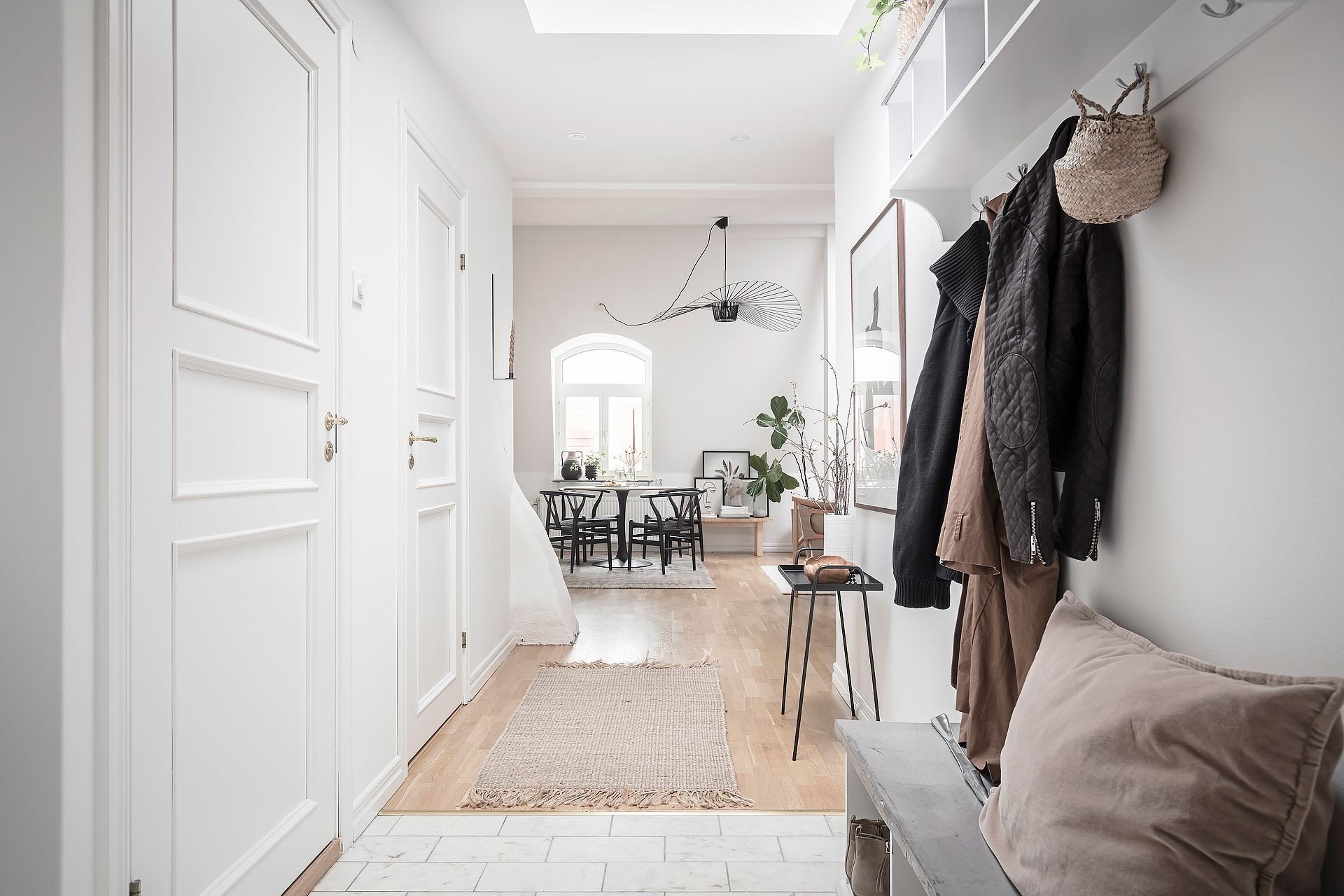 Piso con decoración nordica con columnas en el interiore y suelos de madera entrada