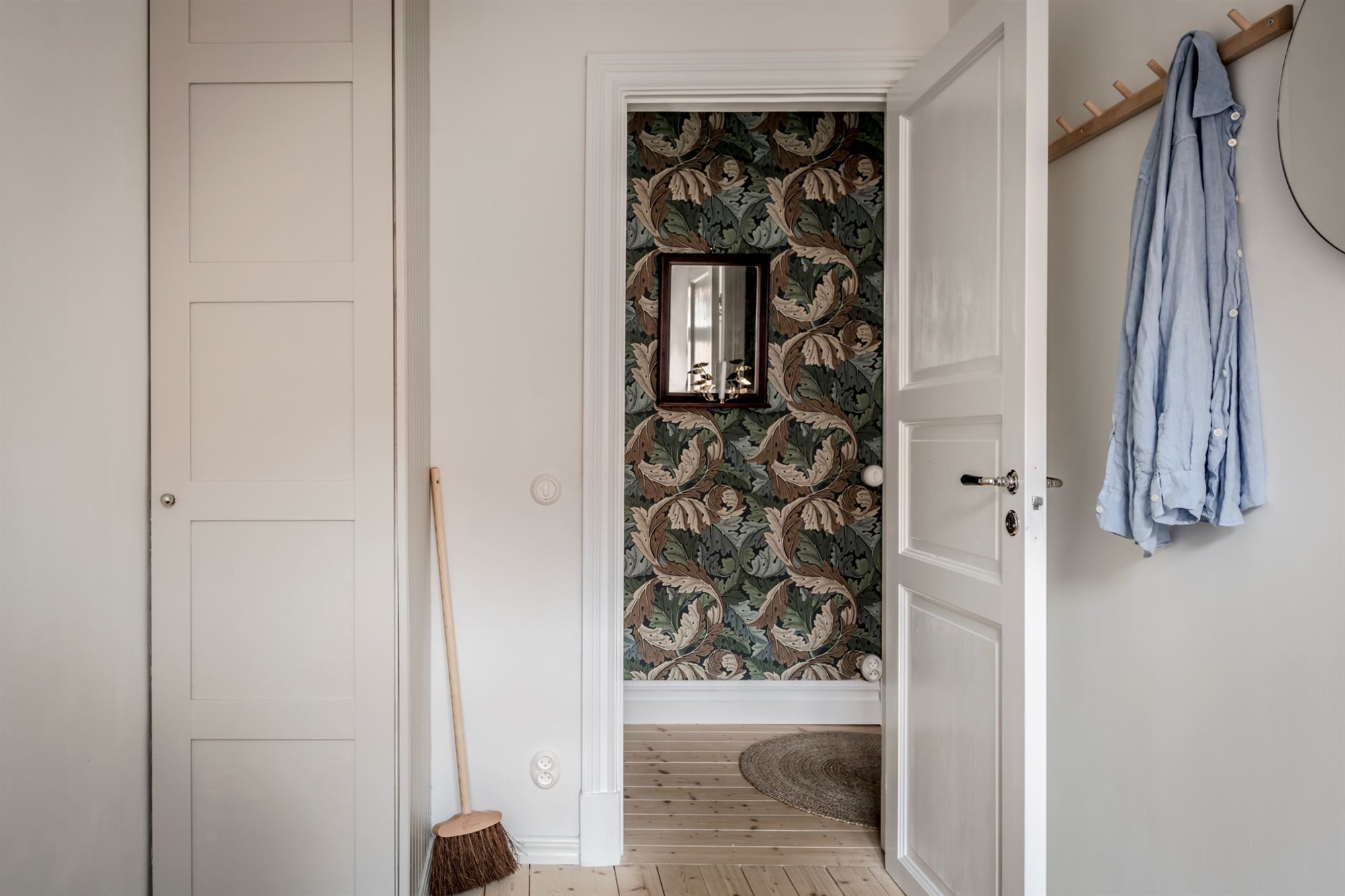 Piso con decoracion nordica y suelos de madera dormitorio con espejo y colgador
