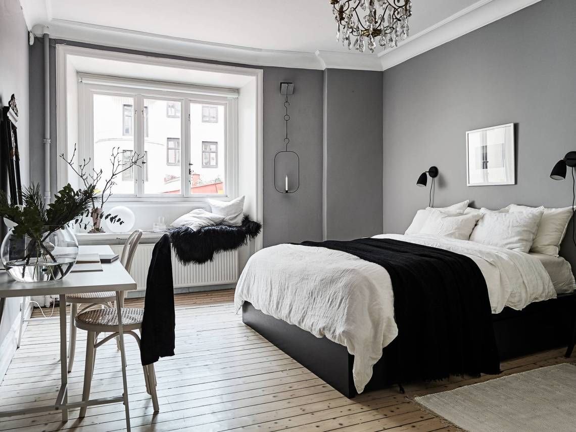 Dormitorio con paredes en color gris y lampara de araña