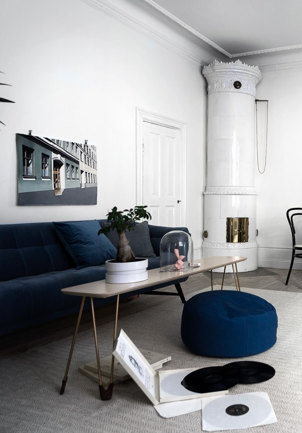 salon con chimenea de ceramica y otomana y sofa de terciopelo azul