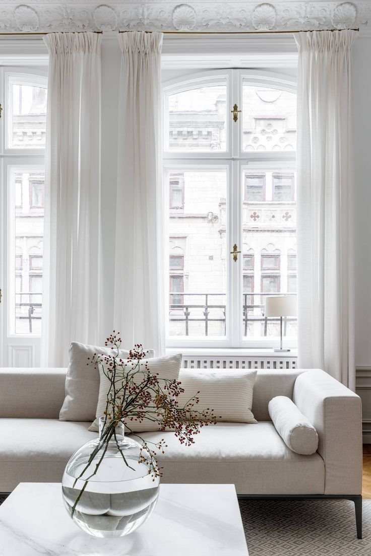 salon con techos con molduras y cortinas con grandes ventanas